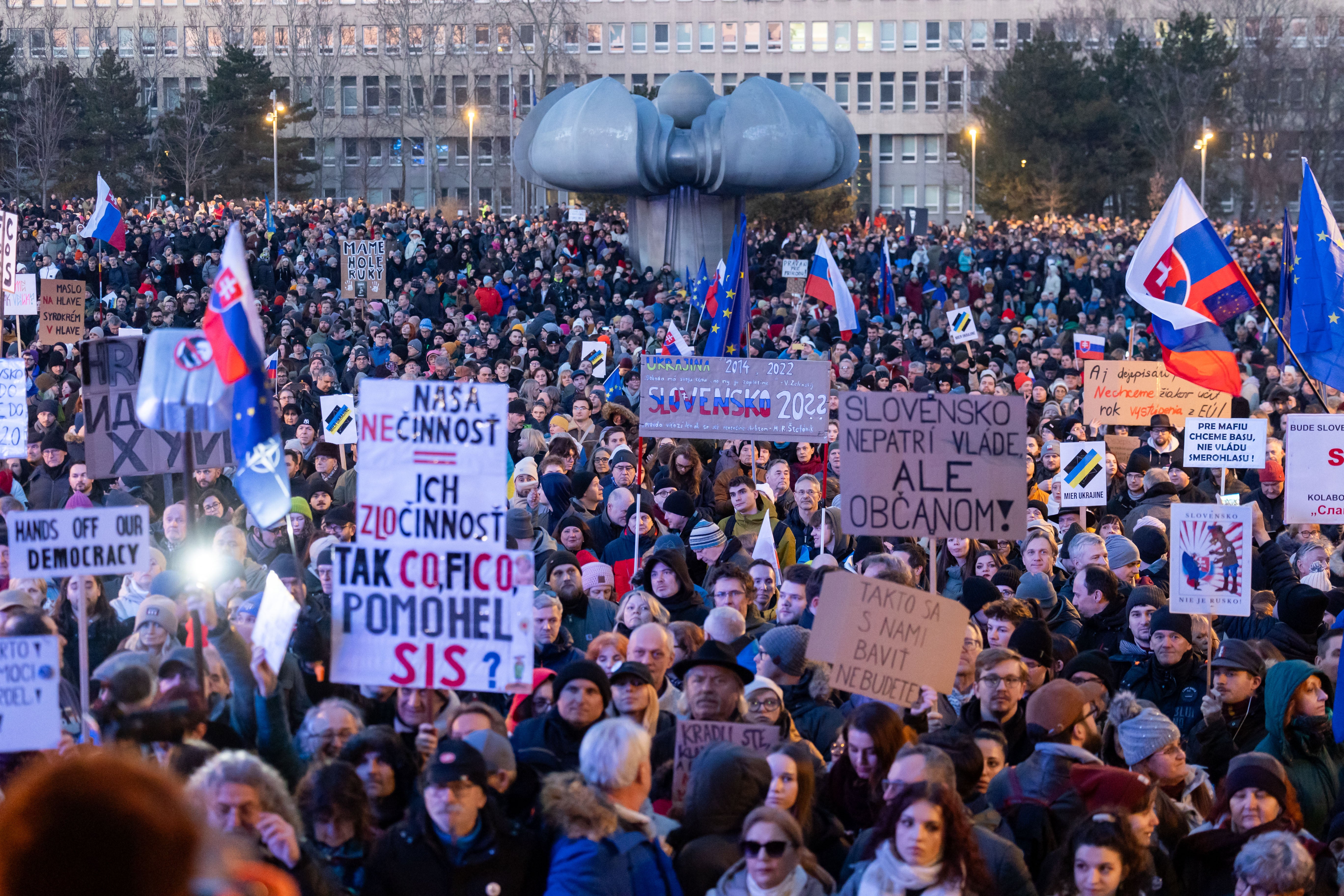 Hundreds of people hold placards as they take part in an anti-government protest in Bratislava, Slovakia, on Friday