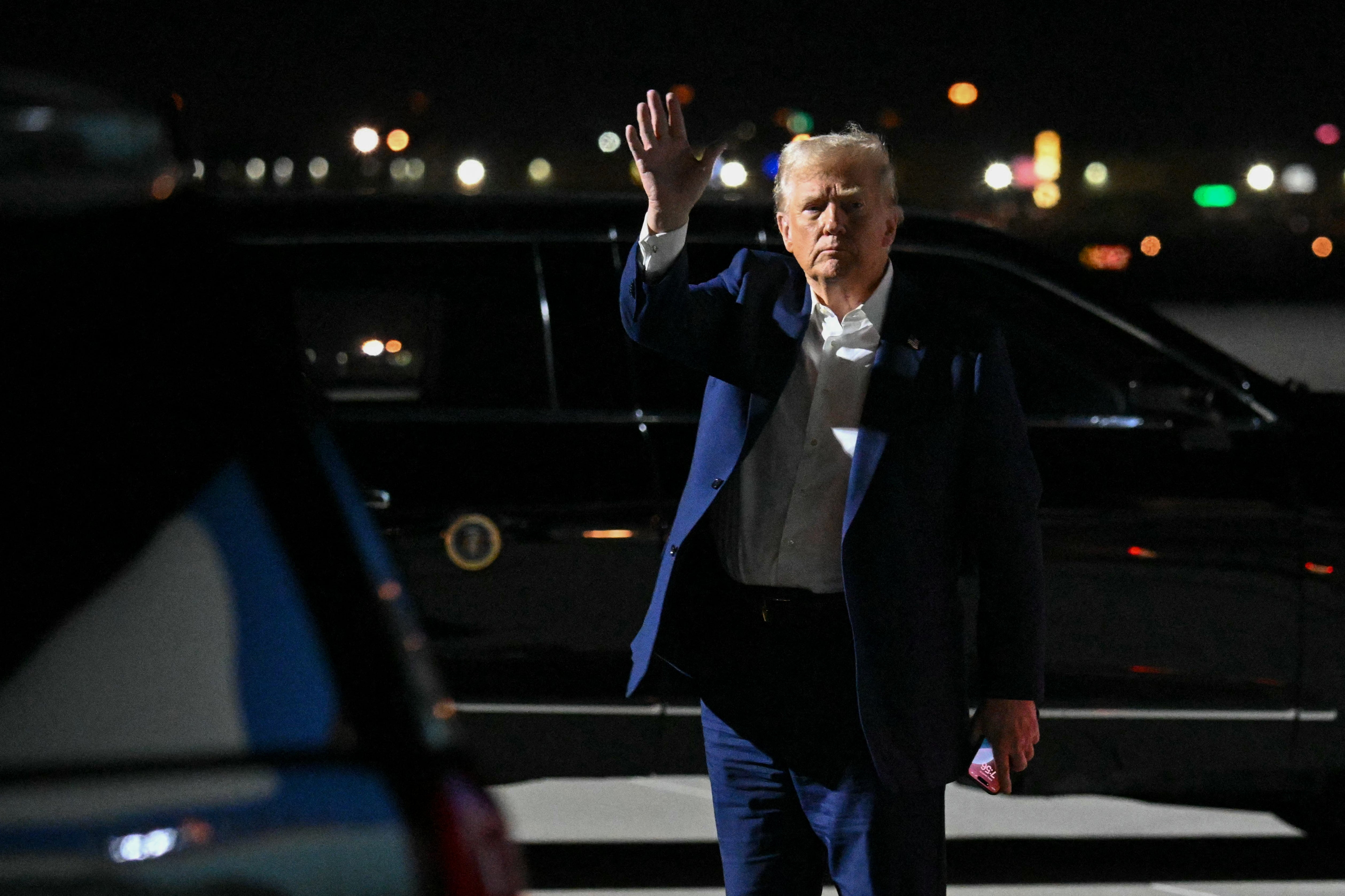 President Donald Trump waves after stepping off Air Force One upon arrival at Harry Reid International Airport in Las Vegas. On Friday night, he fires several government watchdogs