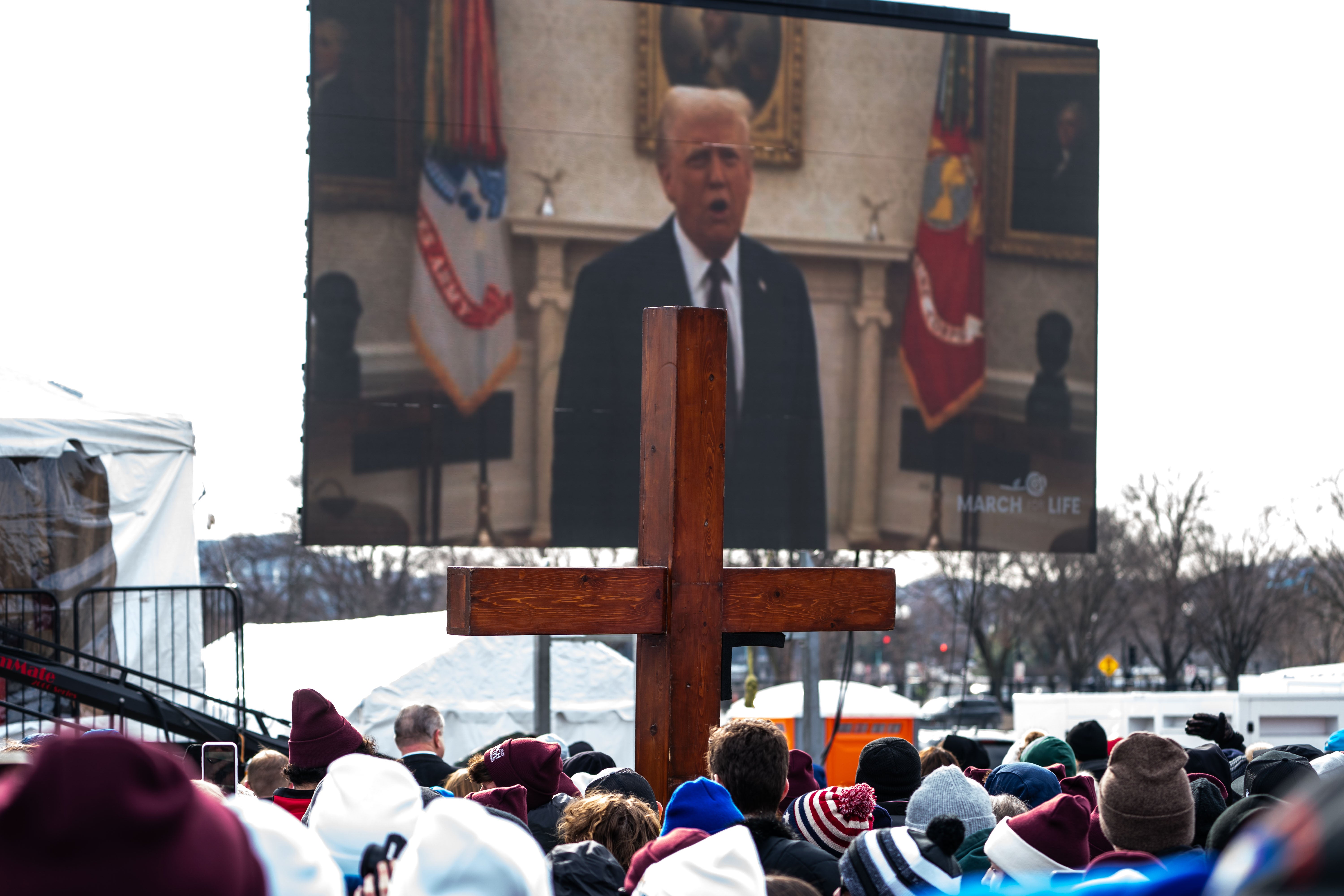 People attending the annual March for Life rally watch a pre-taped video recording of President Donald Trump. The president revived a pair of anti-abortion policies to cap off the first week of his second term, one day after pardoning anti-abortion activists