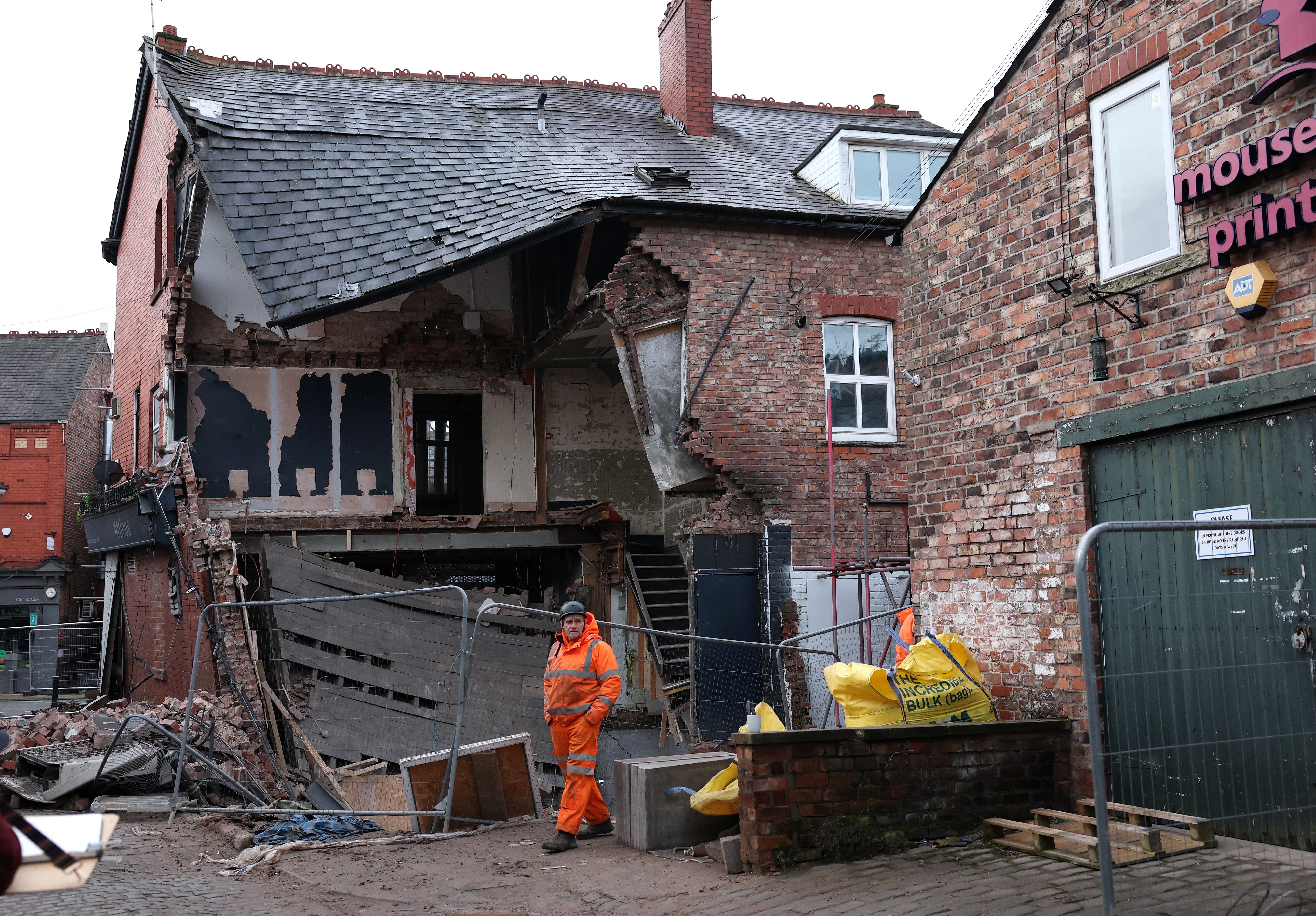 A worker inspects damage to a partially collapsed building that was undergoing repairs before being damaged by high winds during Storm Eowyn