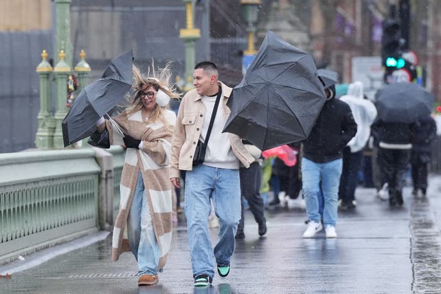 People walking in the wind and rain on Westminster Bridge, London (Yui Mok/PA)