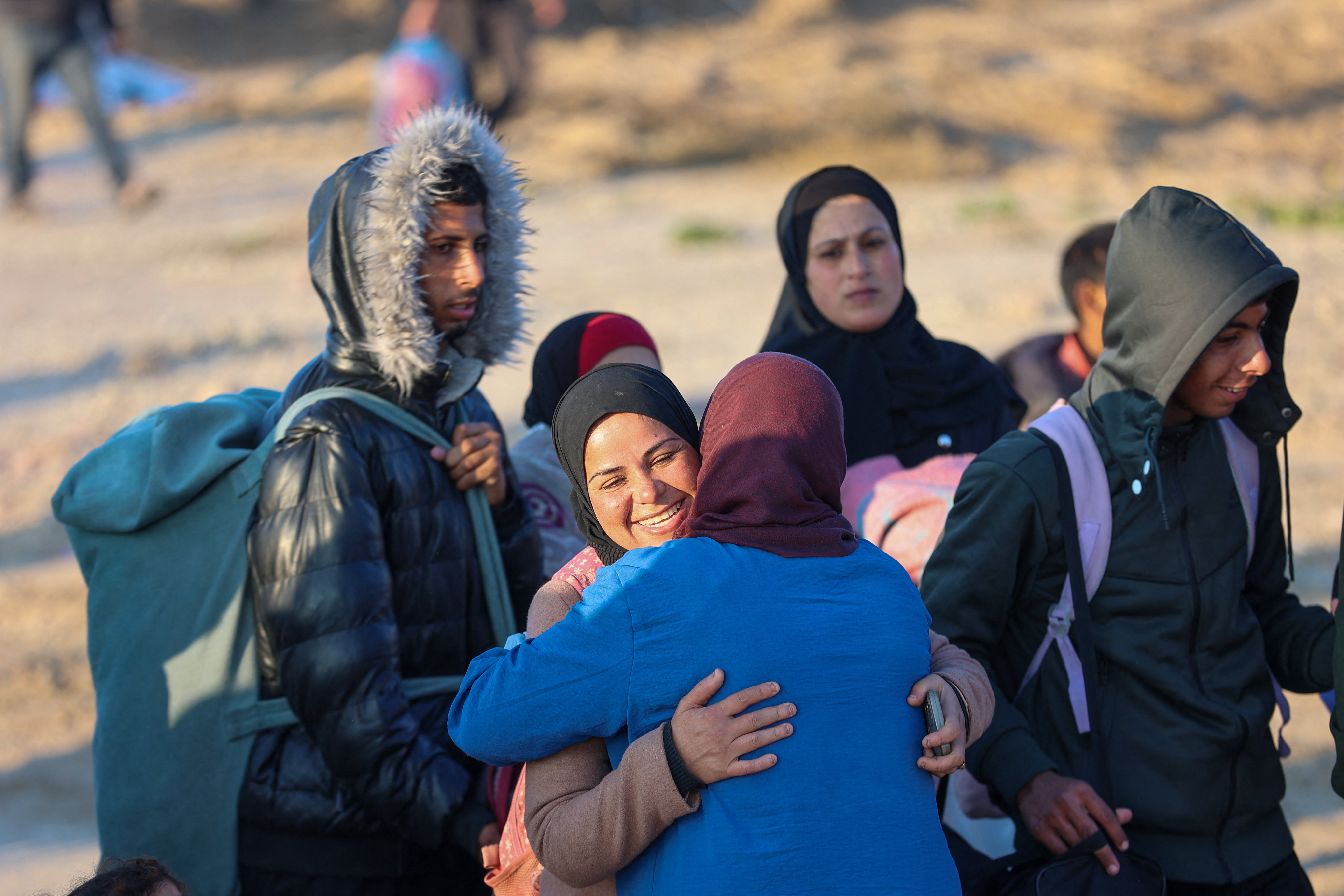 Displaced Gazan women hug each other as they cross the Netzarim corridor from the southern Gaza Strip into Gaza City