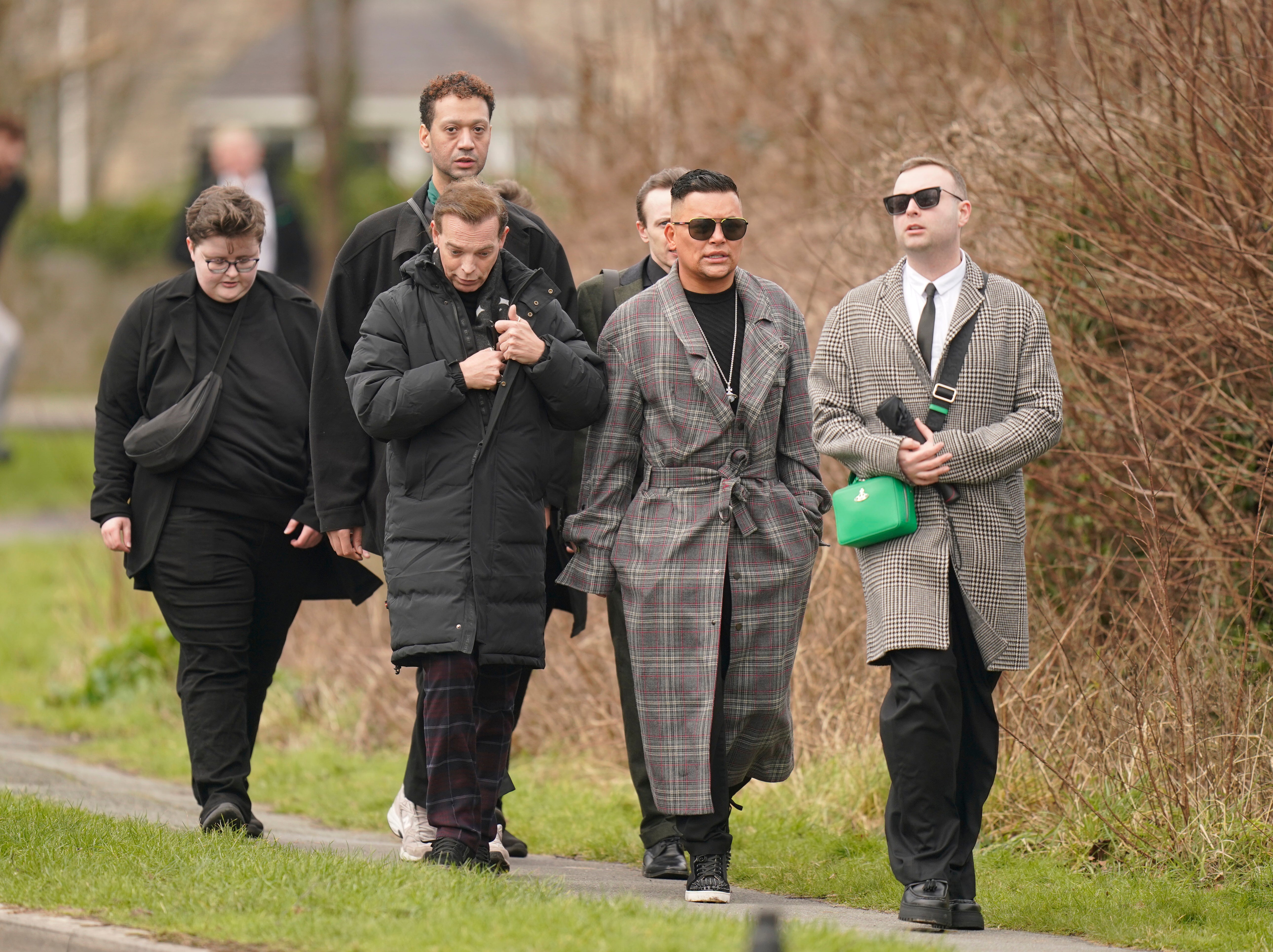 As competidoras da Drag Race UK Tia Kofi, Baga Chipz (segunda à direita) e Cheryl (à direita) chegam para o funeral de The Vivienne em Bodelwyddan, Denbighshire