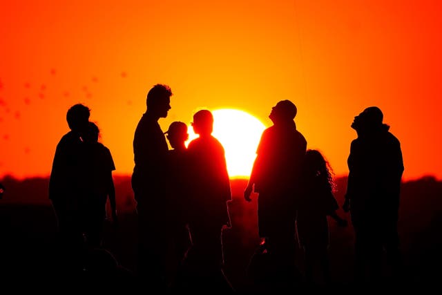 People watching the setting sun in a heatwave (Victoria Jones/ PA)