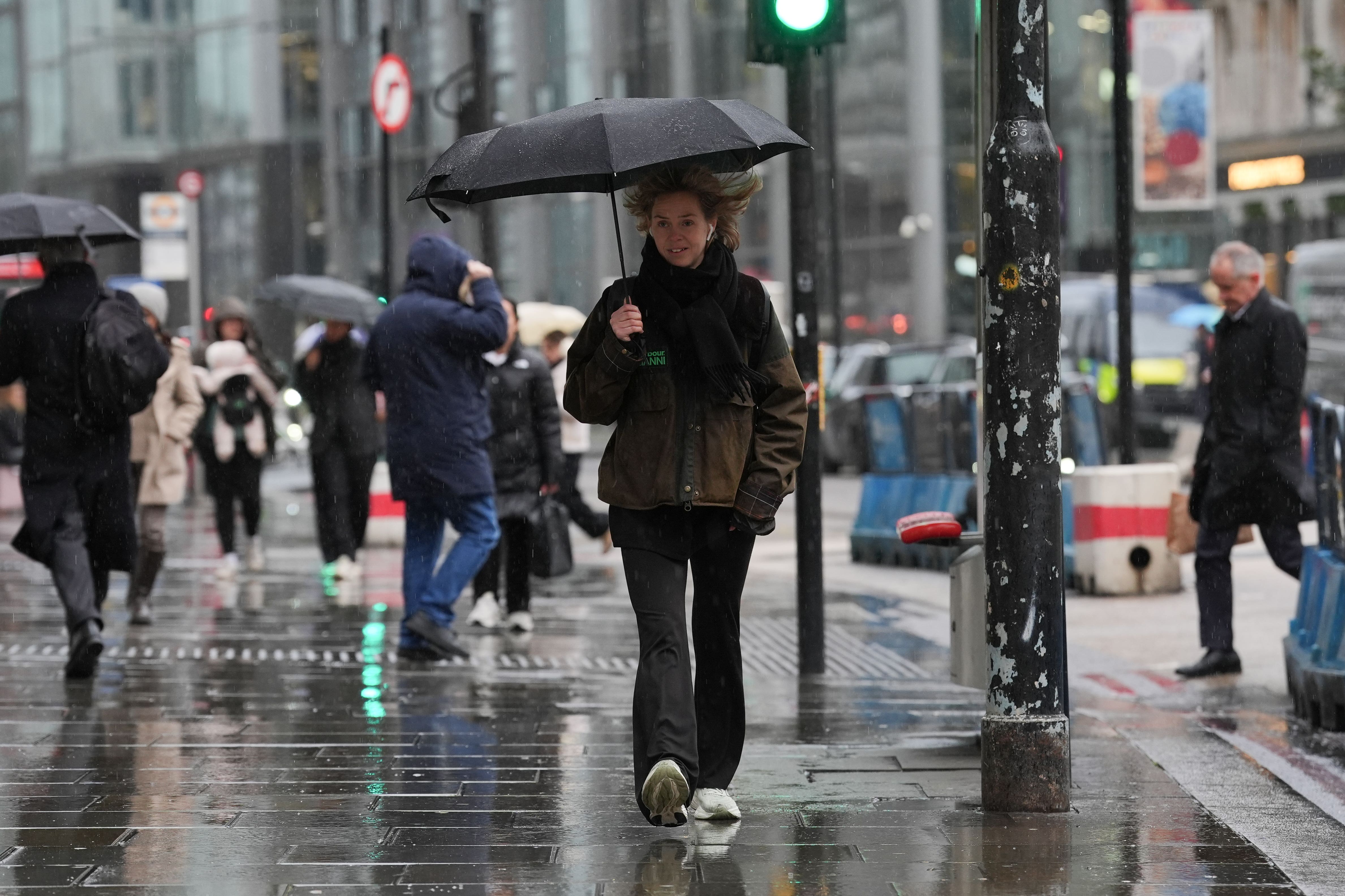 A person using an umbrella to shelter from the rain while walking in Shoreditch, London (Lucy North/PA)