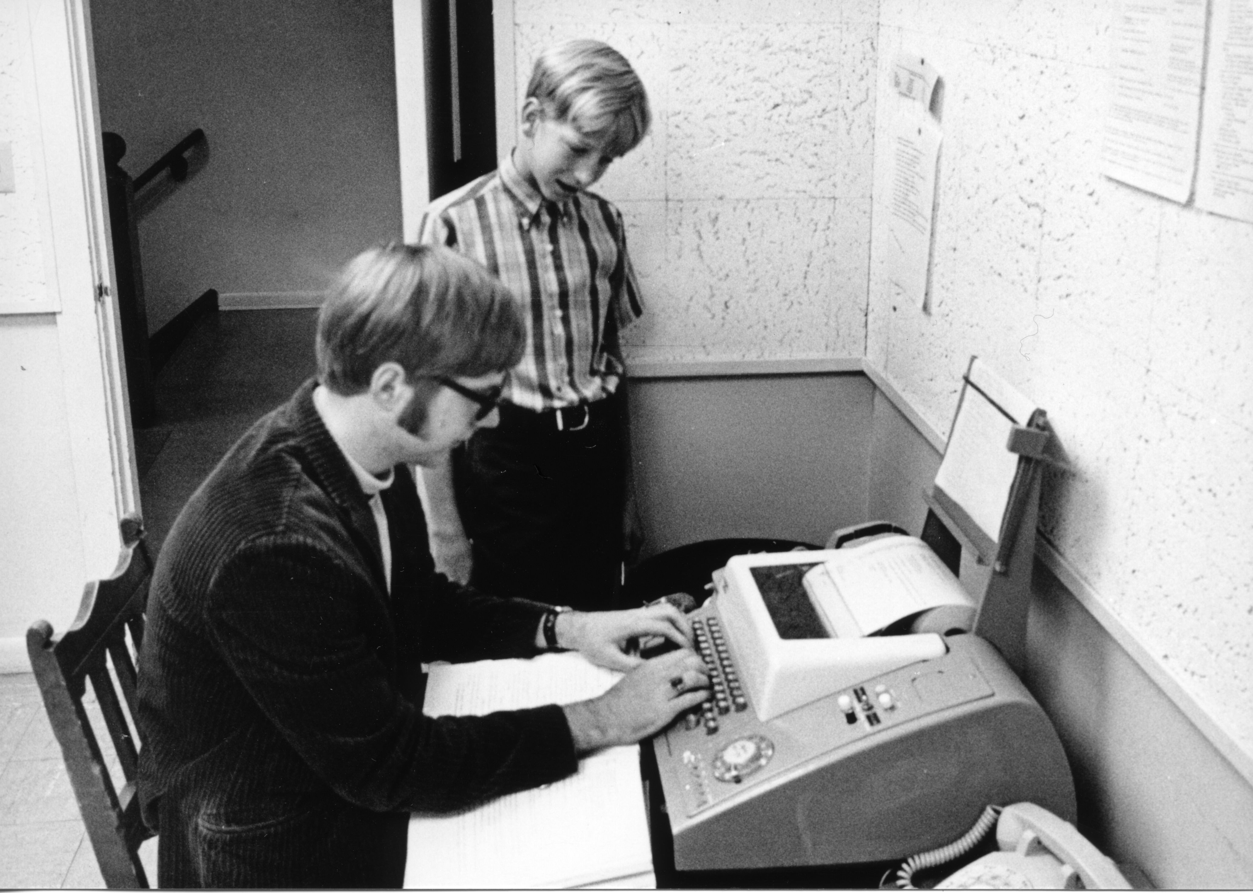 Bill Gates watches his future Microsoft co-founder Paul Allen use a teletype machine in a photo from the Lakeside School yearbook (1969-1970)