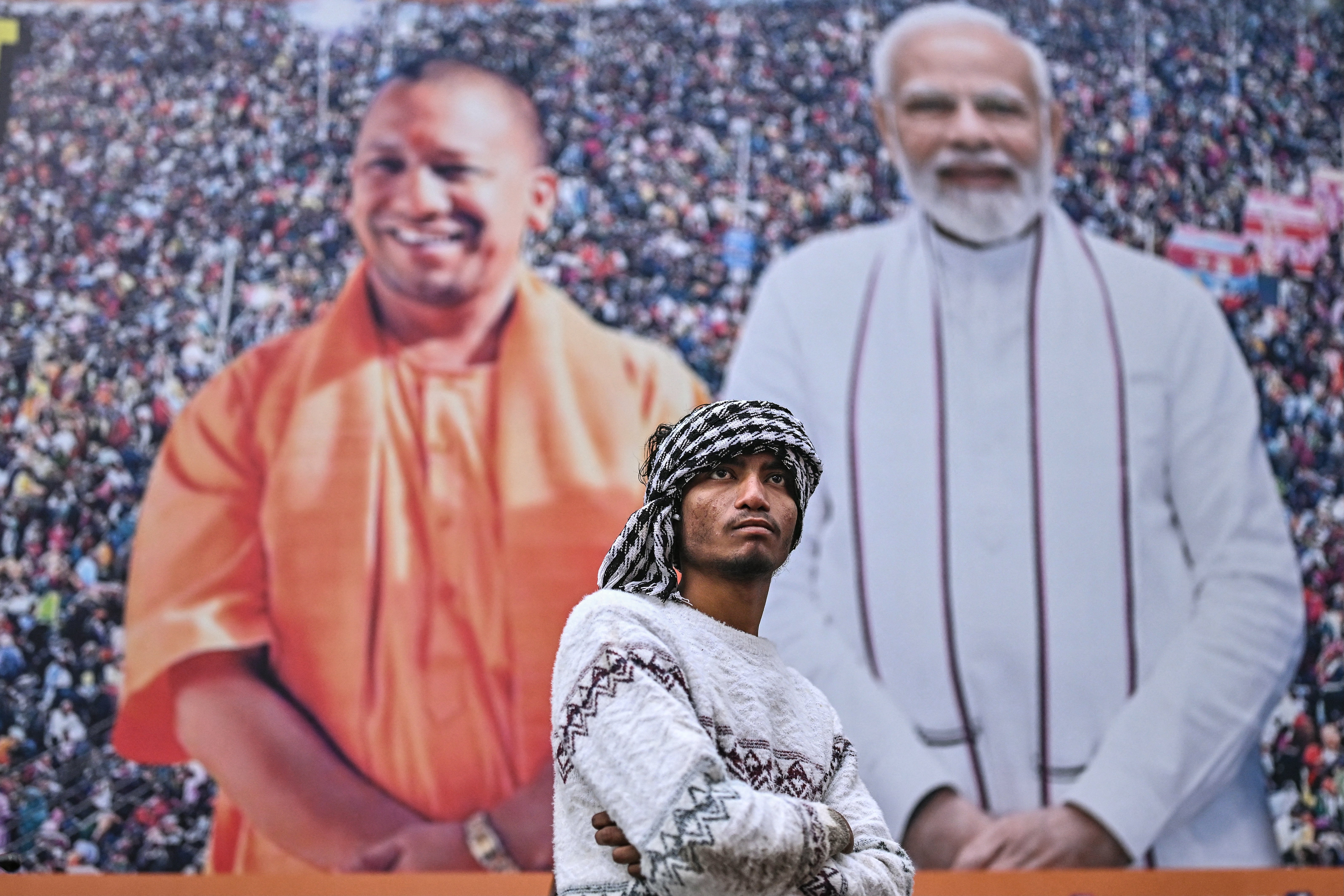 A antheral   stands successful  beforehand   of a poster featuring India’s premier  curate  Narendra Modi and Uttar Pradesh main  curate  Adityanath connected  the eve of the commencement  of the Maha Kumbh Mela festival successful  Prayagraj connected  12 January 2025