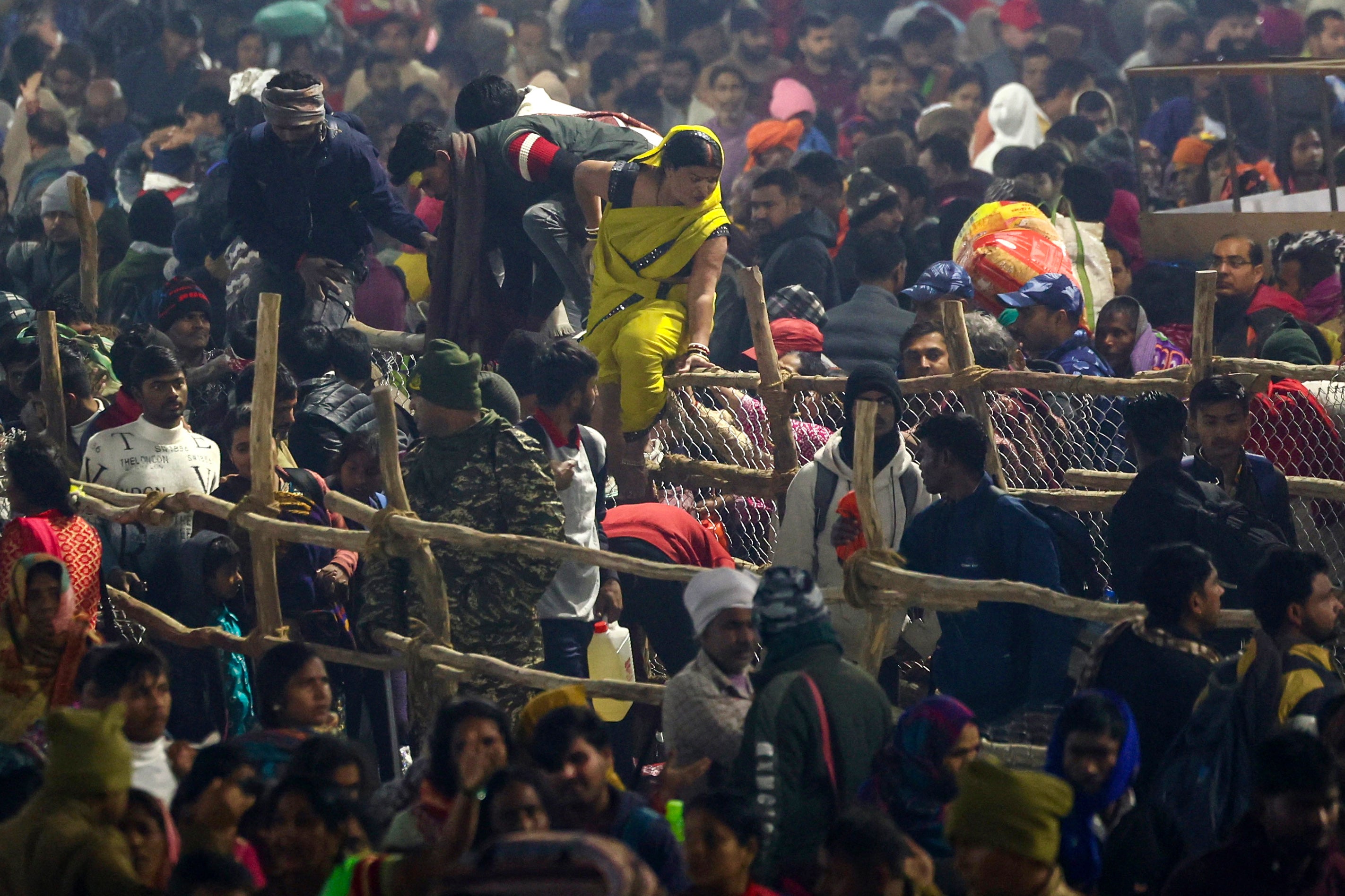 Devotees seen trying to cross a barricade at the site of stampede amid the ongoing Maha Kumbh Mela