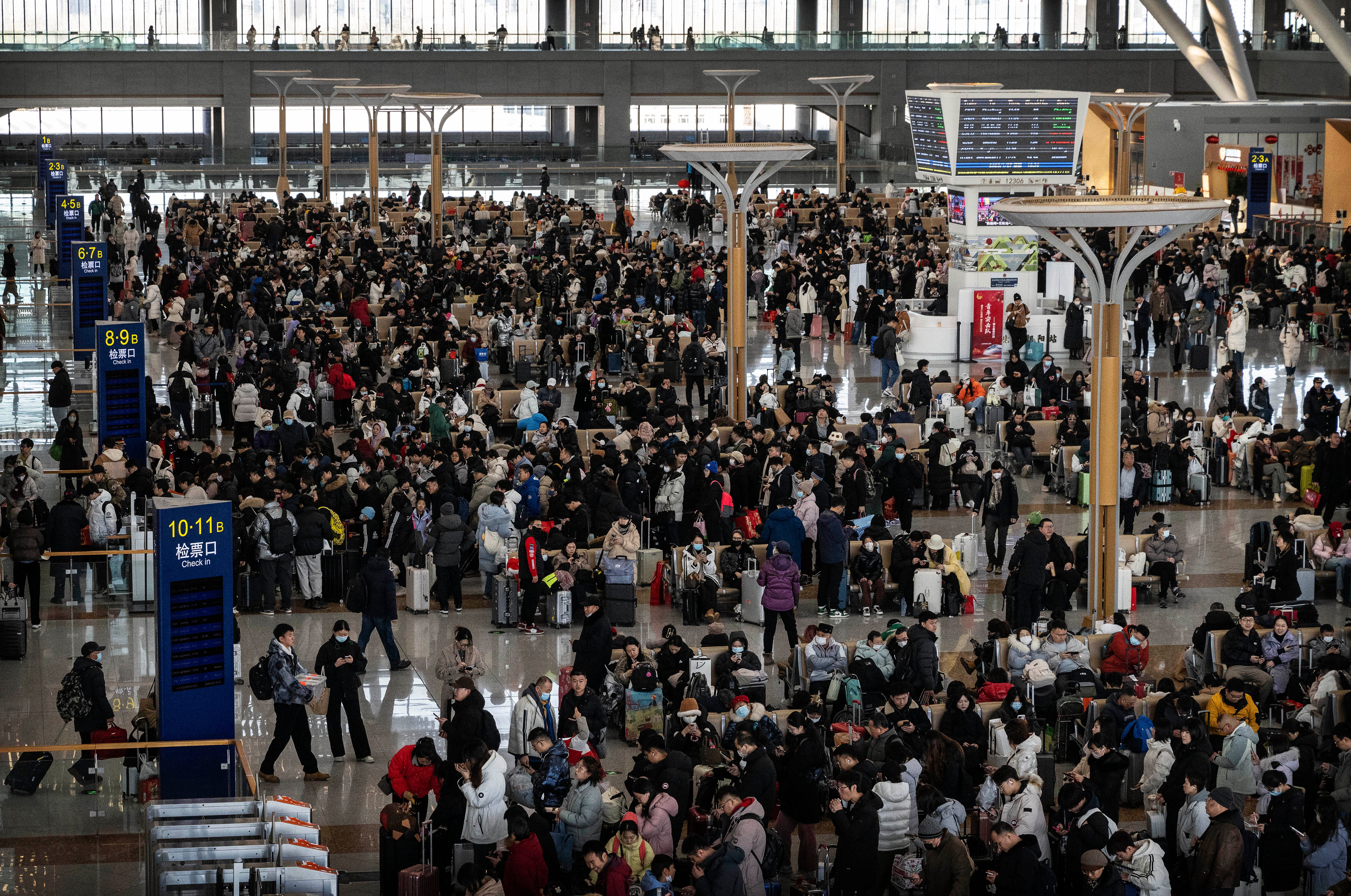 Travellers line up to board high speed trains in Beijing during the travel rush for lunar new year celebrations