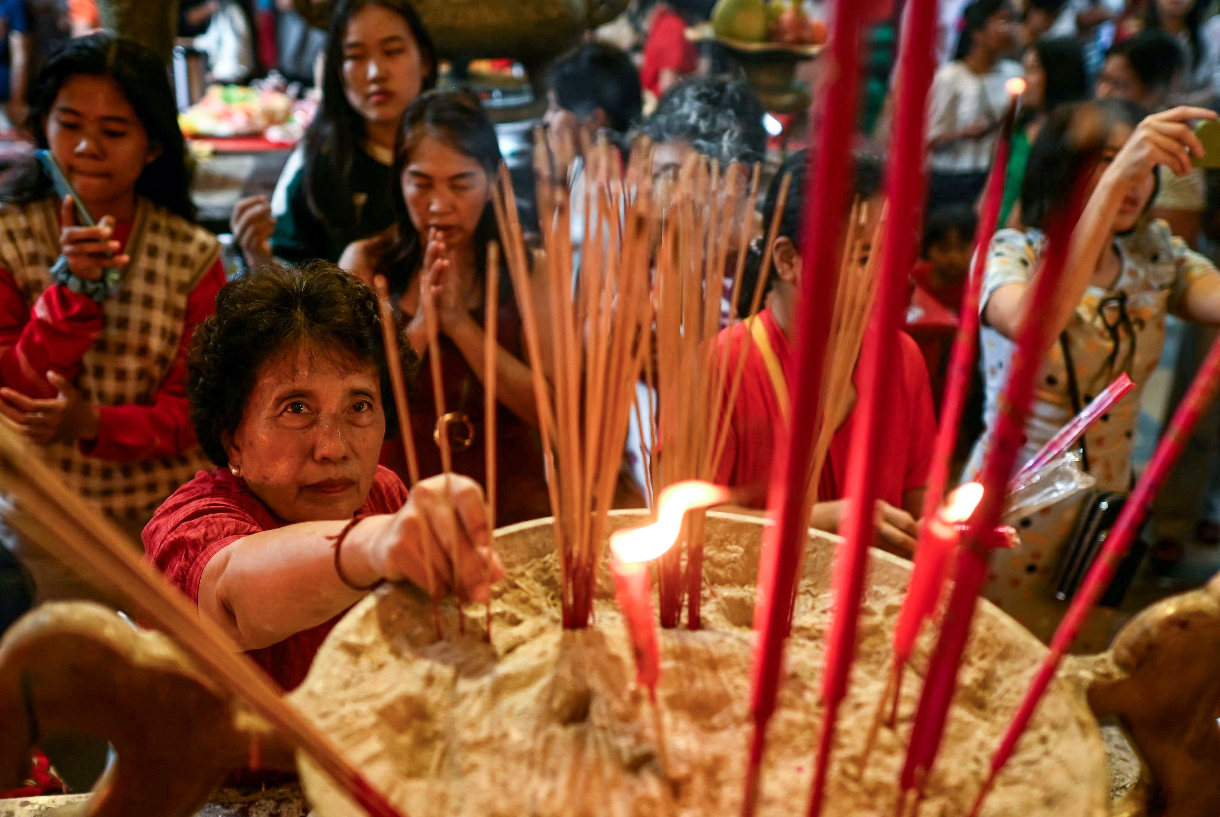 People burn incense as they pray at a Chinese temple in Yangon