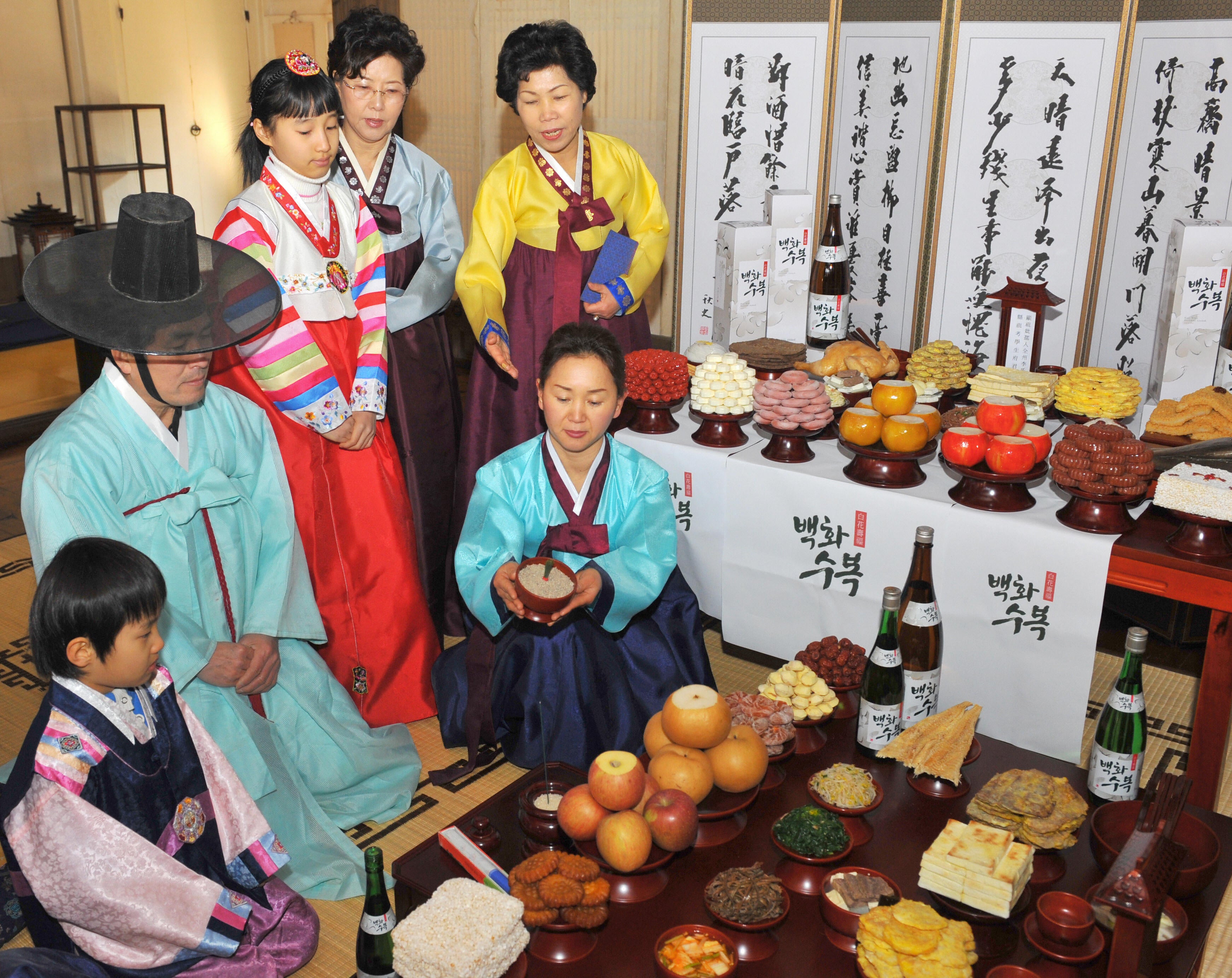 File. South Korean models demonstrate ‘charye’, a traditional ritual service of food and offerings to thank their ancestors, ahead of the lunar new year, at a showcase traditional village in Seoul on 12 January 2009