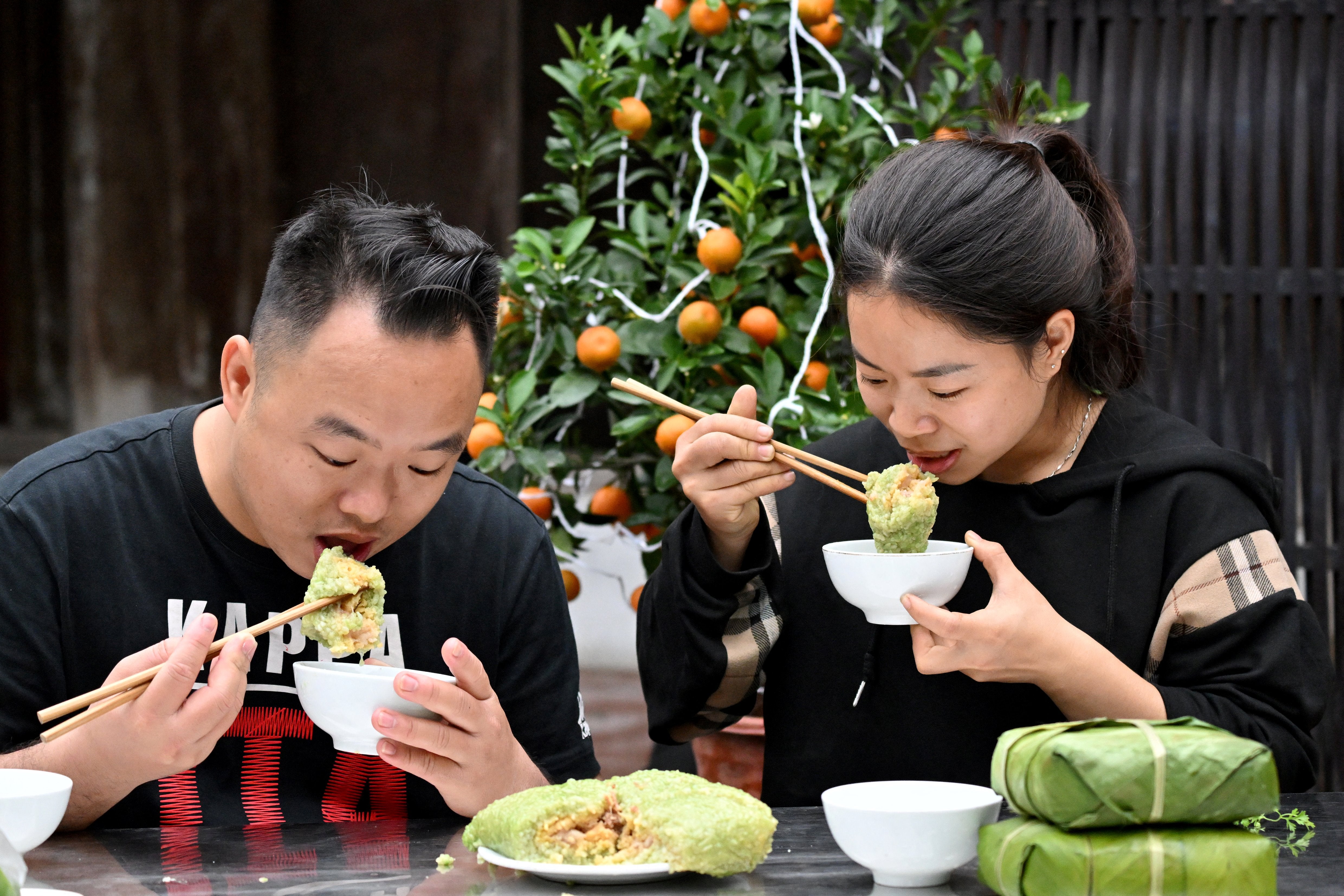 Wrapped cakes of glutinous rice, green beans and pork belly known as banh chung are prepared to celebrate Tet, the Vietnamese new year