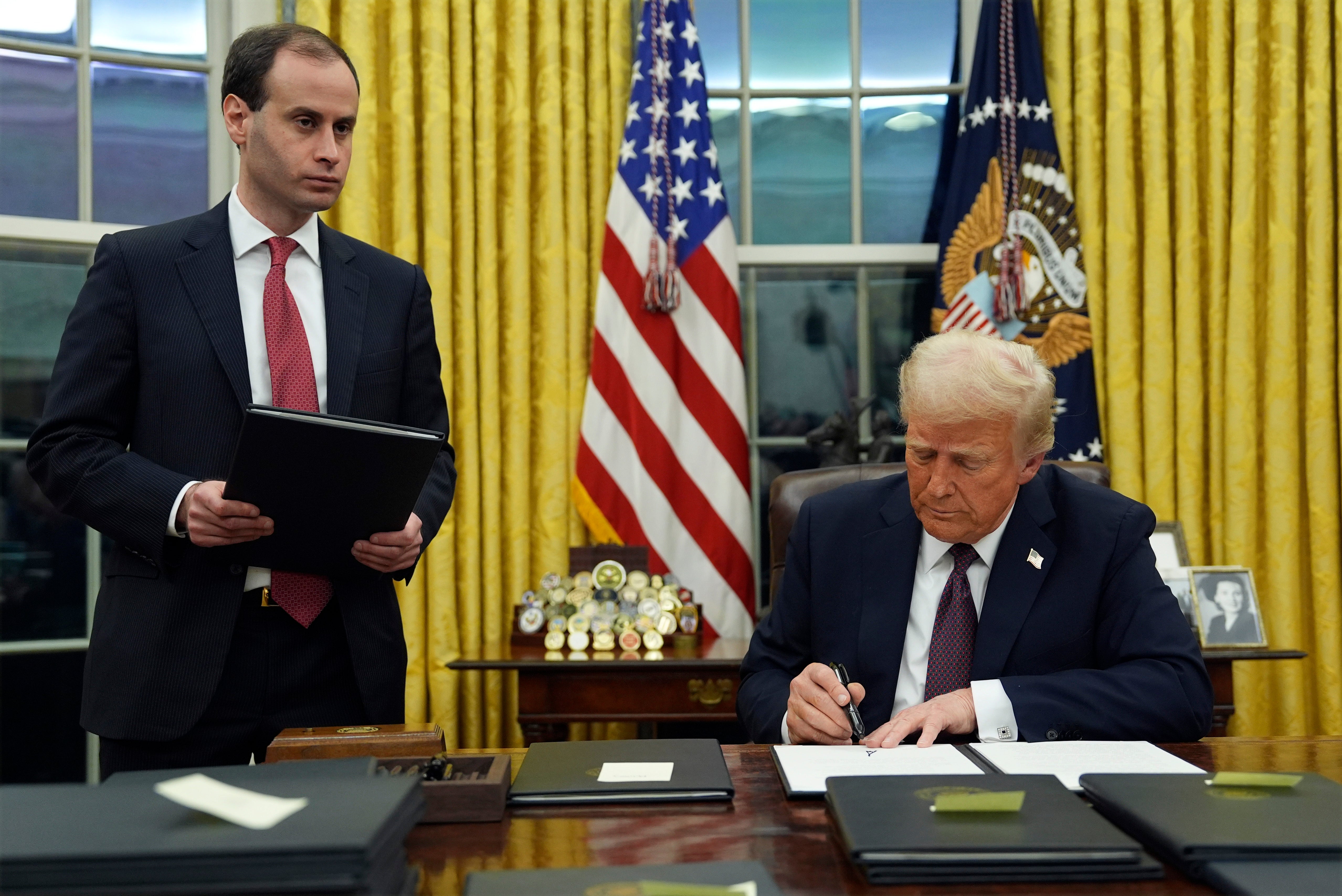 Donald Trump signs an executive order to create the Department of Government Efficiency (DOGE) in the Oval Office of the White House on January 20