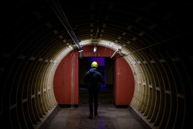 <p>A journalist walks during a press tour of underground tunnels used during World War Two as shelters during the Blitz that are now due be developed into a new tourist attraction called The London Tunnels</p>