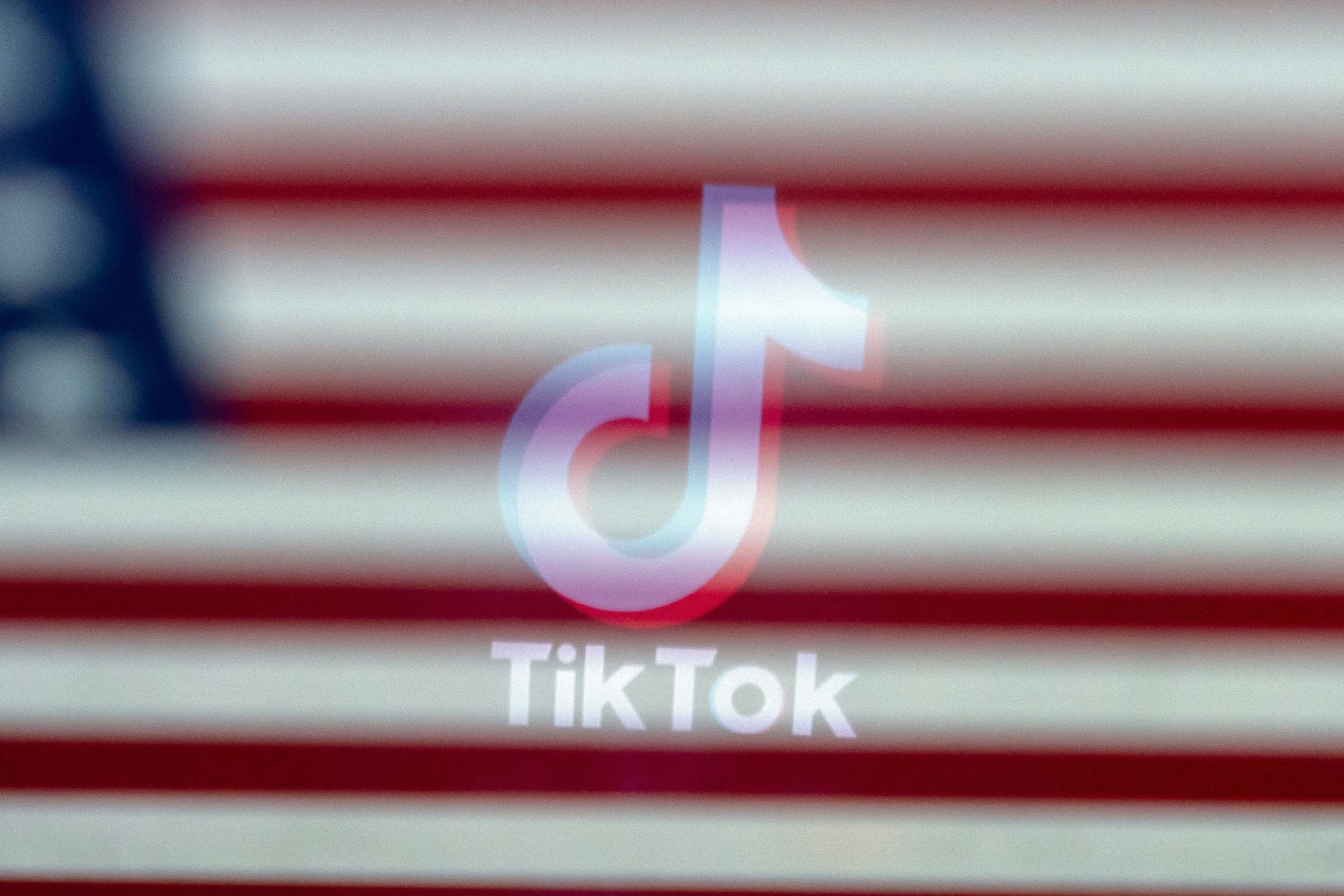 The TikTok logo reflected in an image of the US flag, in Washington, DC, on 16 March, 2023