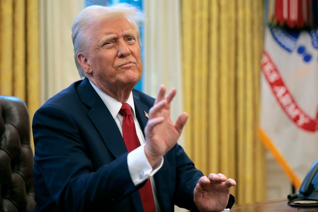 <p>President Donald Trump reacts to a reporter's question from the Resolute Desk after signing an executive order on January 30</p>