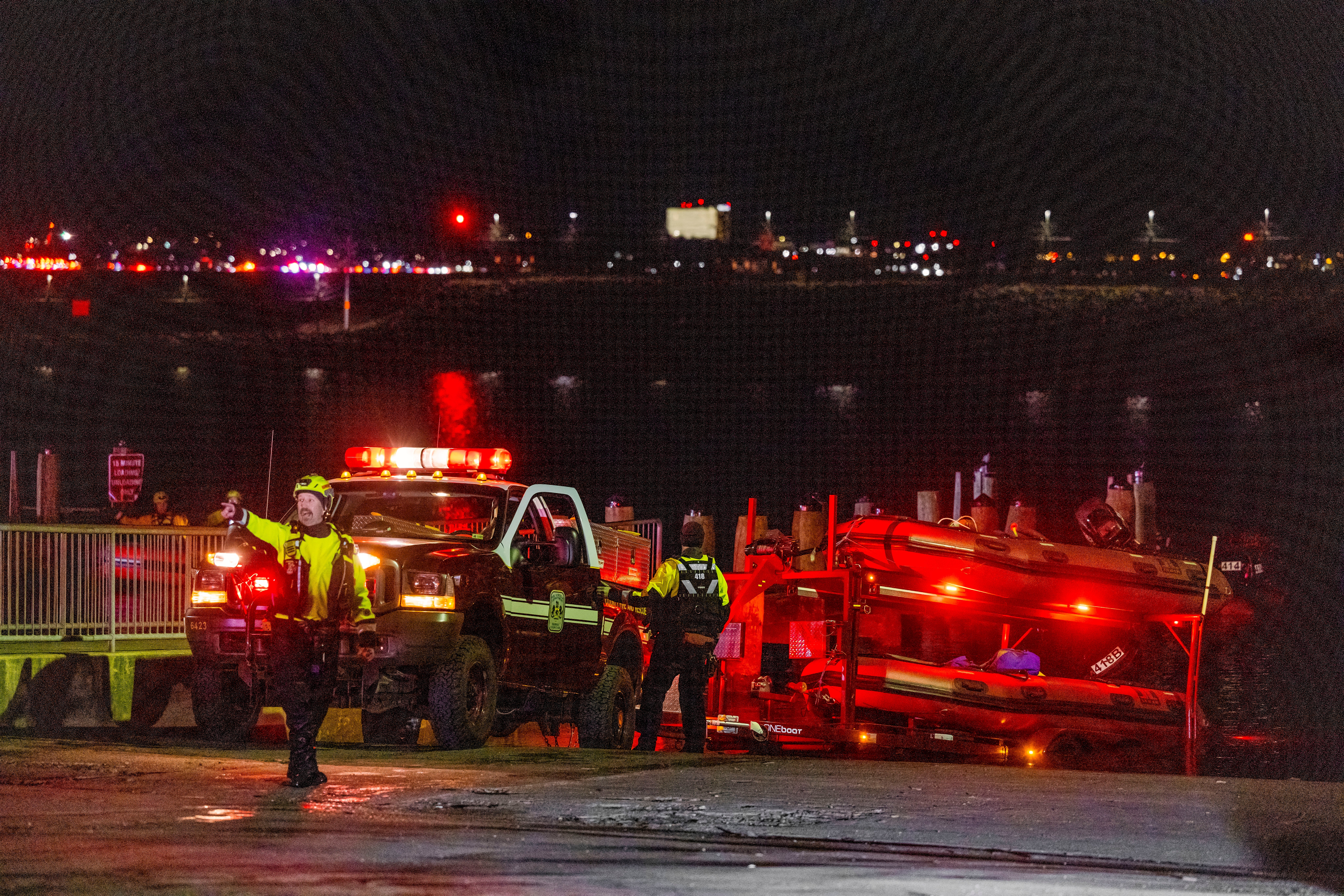 Rescue teams organize to help search the Potomac River after an American Airlines passenger plane collided with a military helicopter on approach to Ronald Reagan National Airport in Washington, D.C.