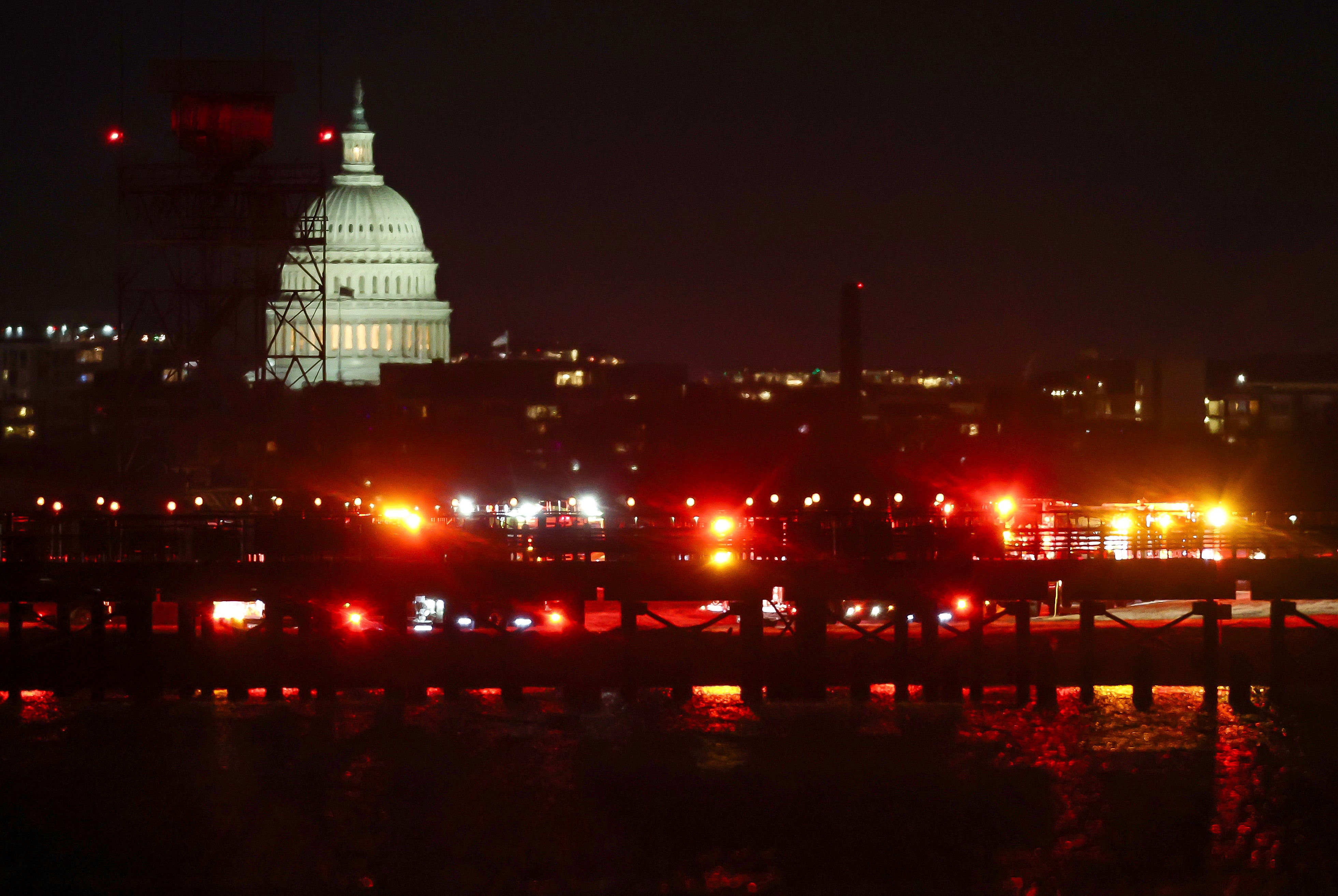 Emergency response units assemble on the tarmac as search and rescue operations are underway in the Potomac River