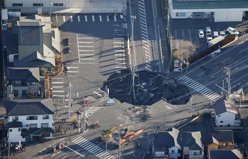 Families near Japan sinkhole asked to evacuate as truck driver remains trapped 