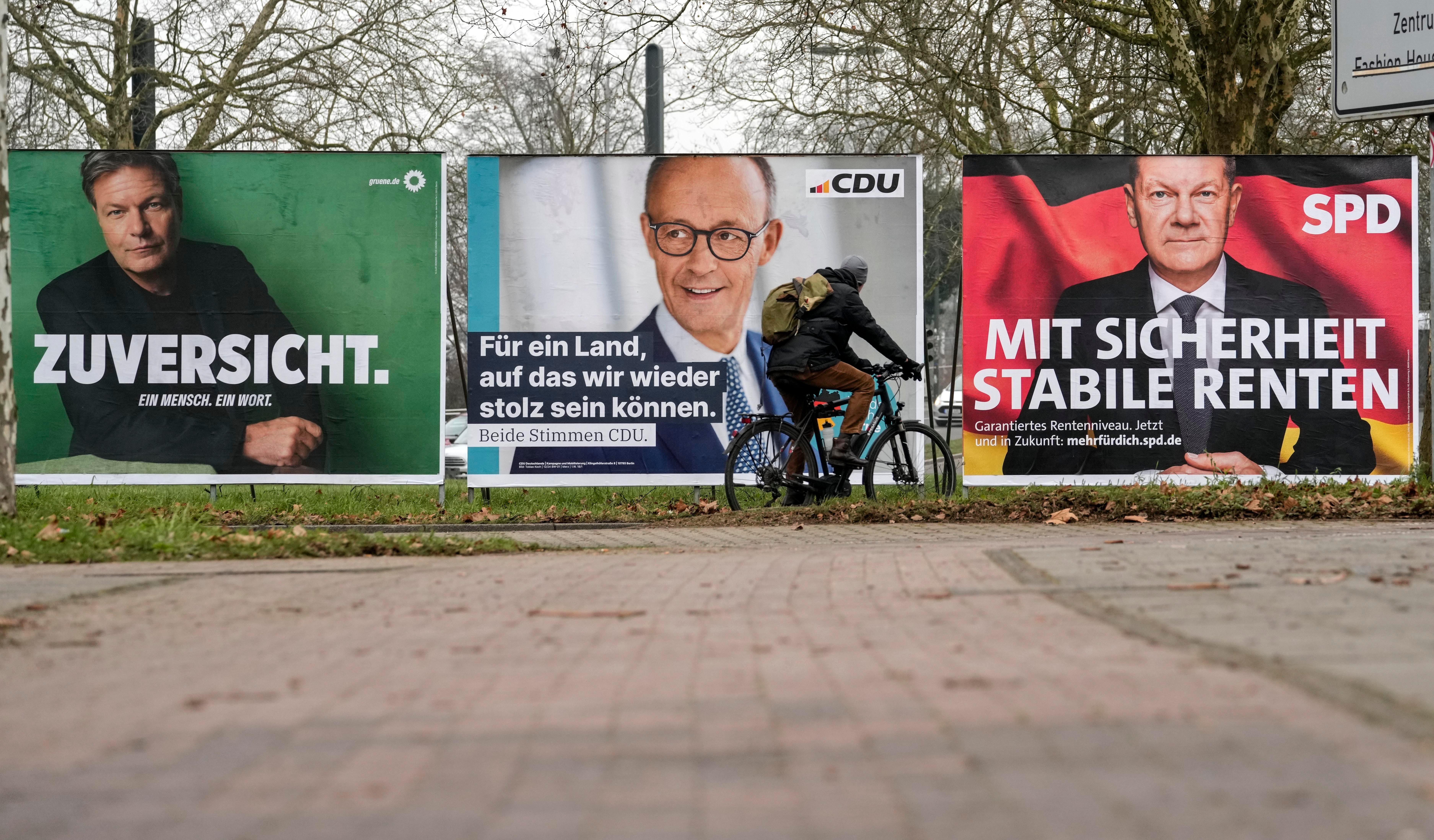 Election posters on a street in Dusseldorf, Germany, show the top candidates for chancellor: Robert Habeck of the Green Party, Friedrich Merz of the CDU, and Olaf Scholz of the SPD, from left