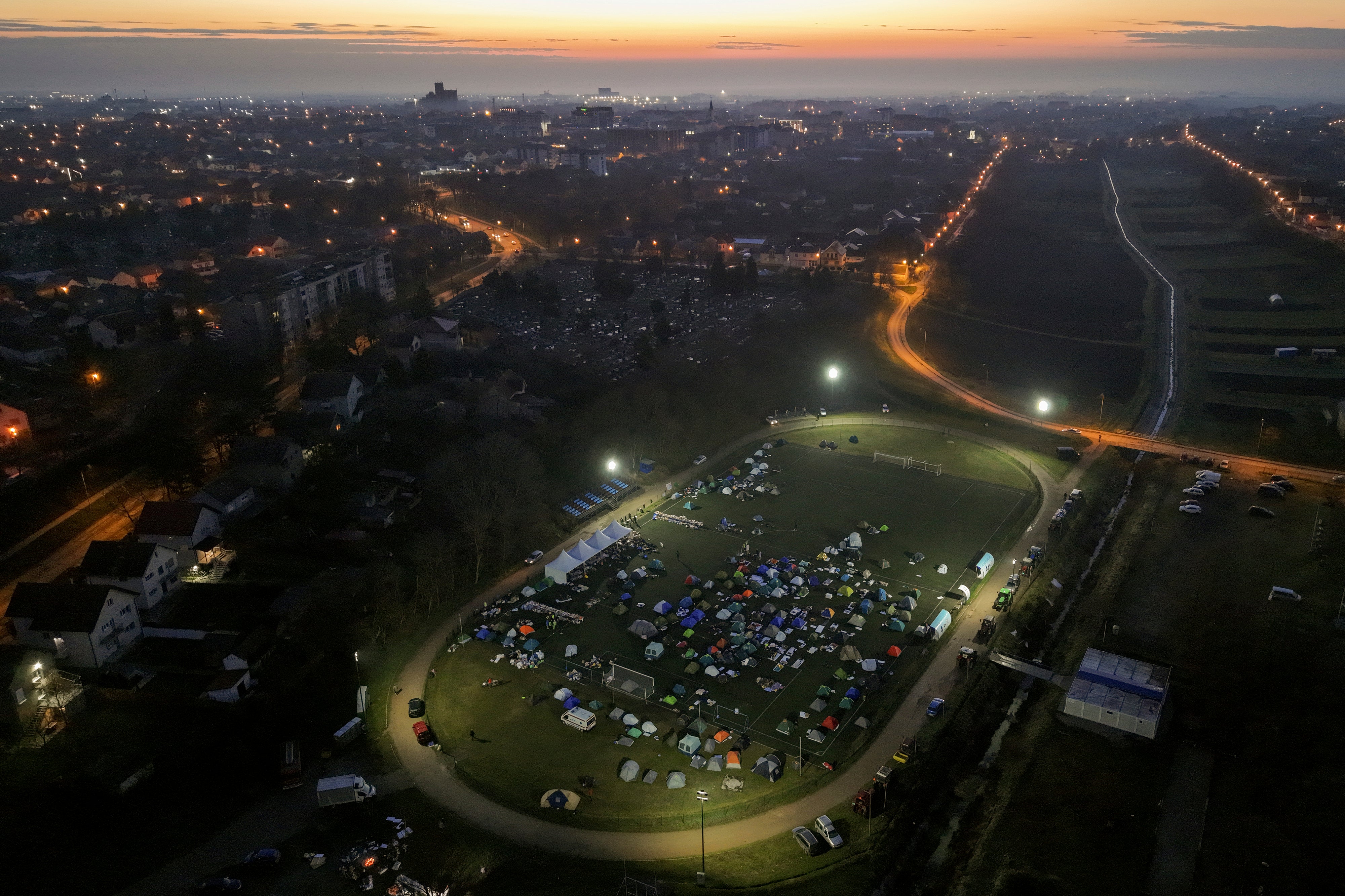 An aerial view of students sleeping in their tents on a soccer stadium