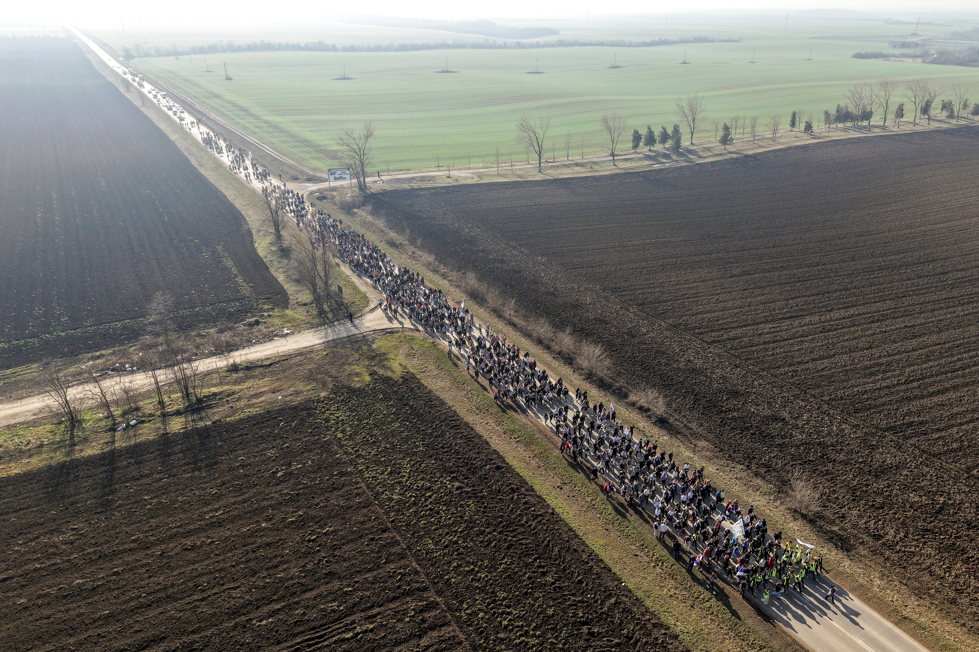 Students march trough the fields in northern Serbia as they protest over the collapse of a concrete canopy