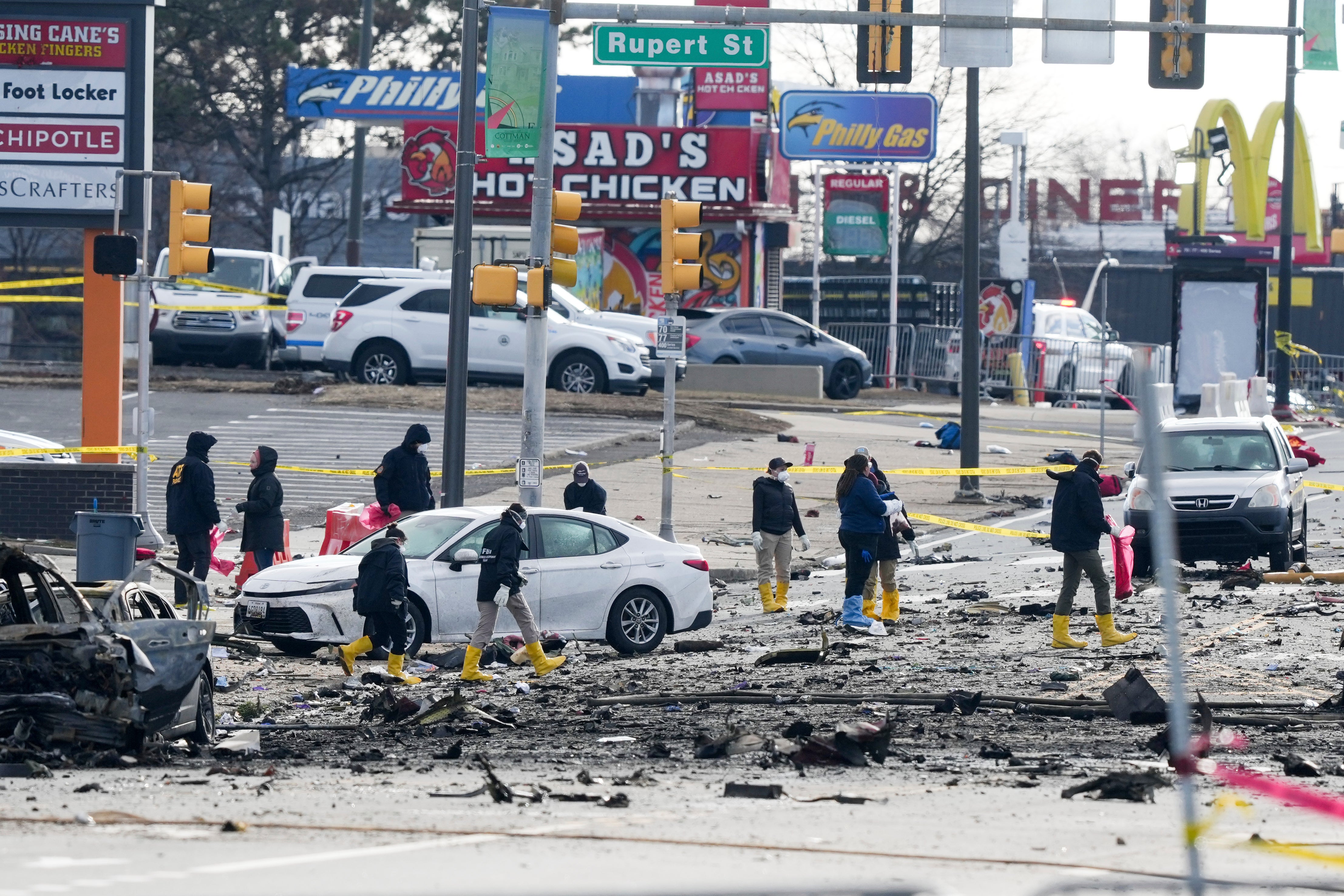 Investigators work the scene on Saturday. On Friday, a small medical jet carrying six people crashed in Philadelphia