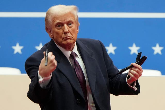 <p>President Donald Trump throws pens used to sign executive orders to the crowd during an indoor Presidential Inauguration parade event in Washington</p>