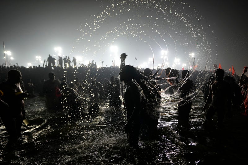 Hindu ascetic rising from the river after a holy dip is emblematic of Maha Kumbh festival in India