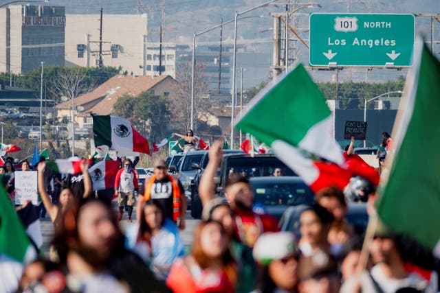 <p>People march along Route 101 during a protest against arrests and deportations of migrants by government agencies in Los Angeles, 2 February</p>