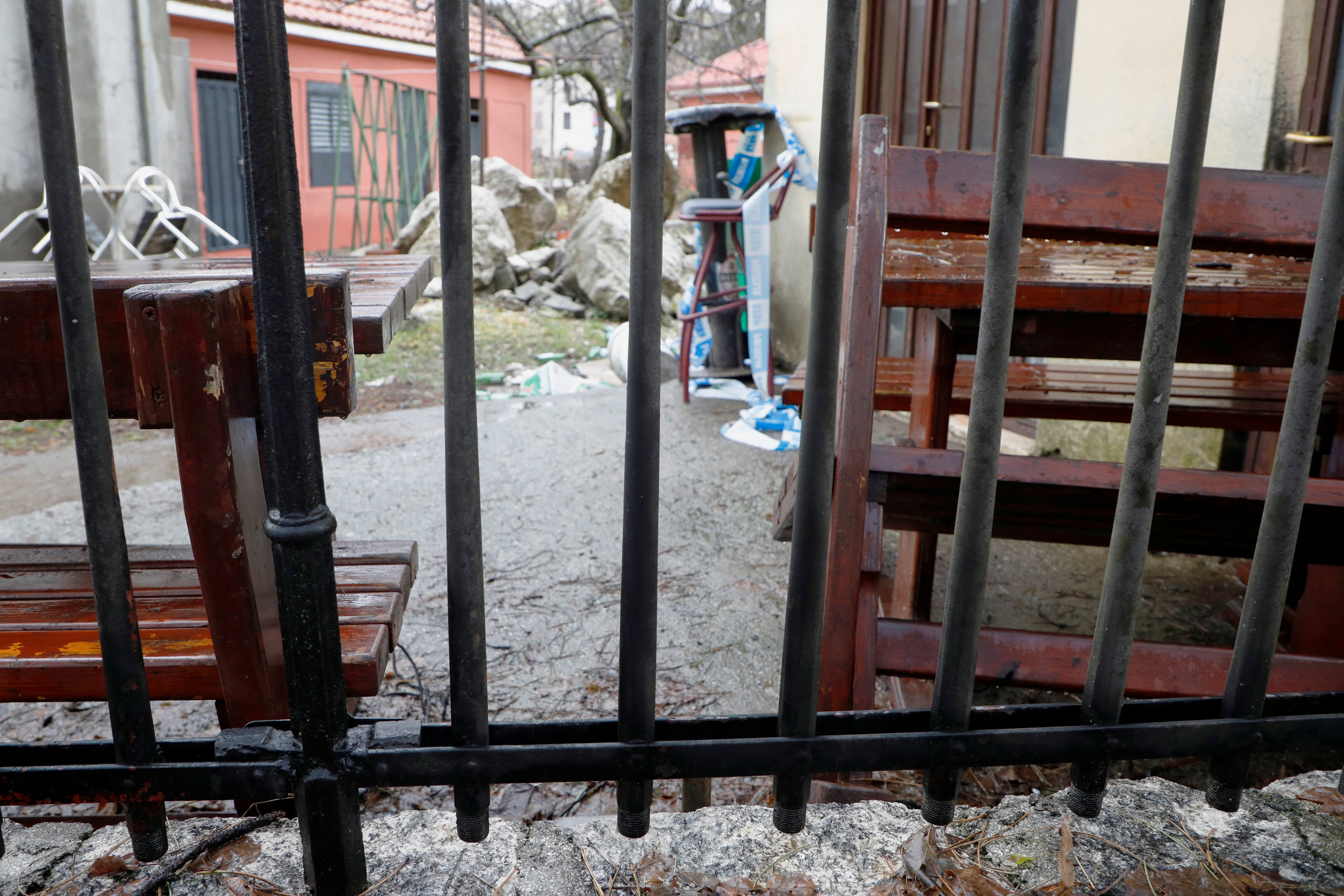 Police line ribbon hangs on the table behind Church fence, made of 1544 muskets, next to a backdoor of the tavern where the January 1st killing spree started, in Cetinje, Montenegro, January 9, 2025