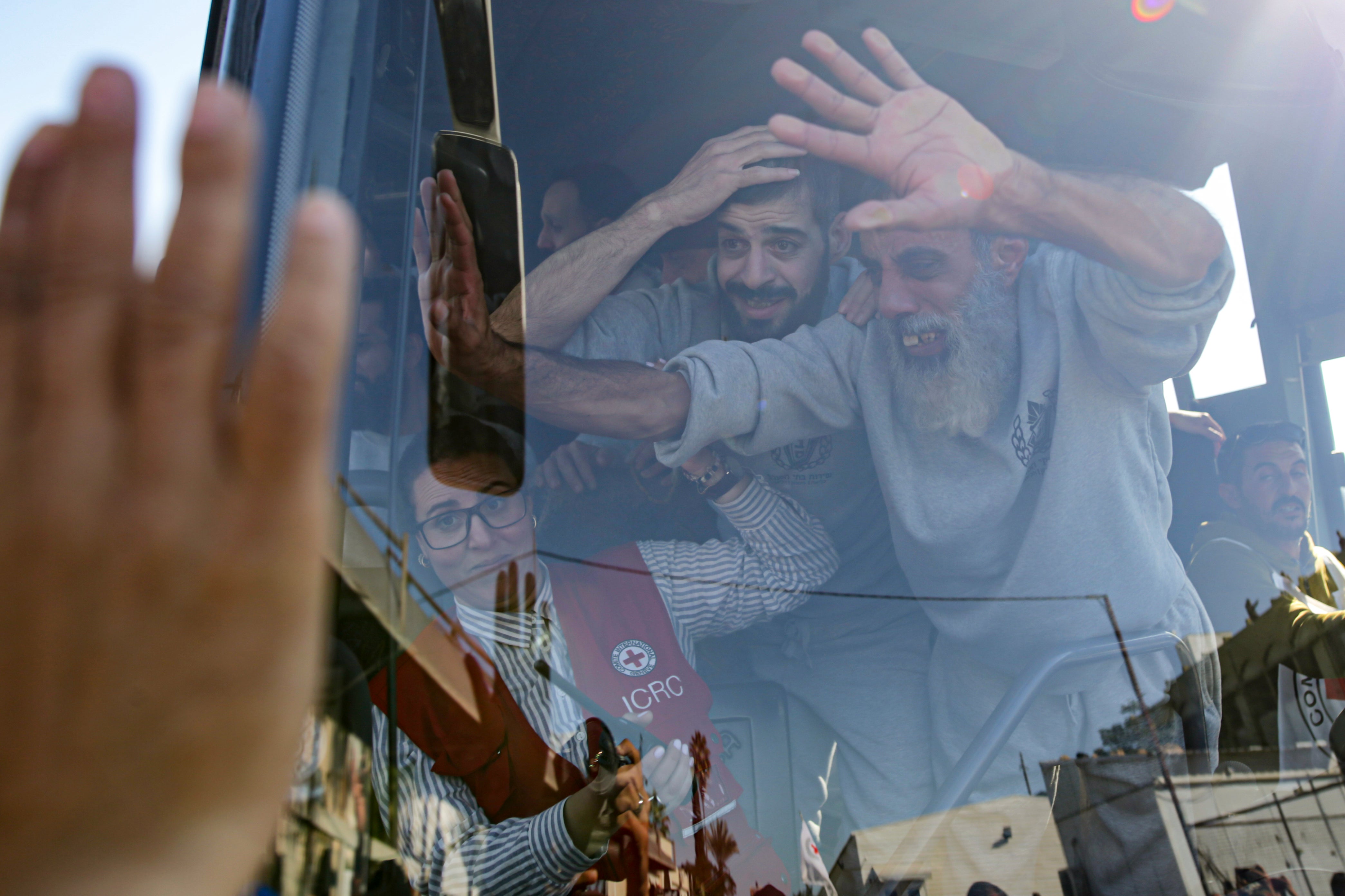 Freed Palestinian prisoners wave from a bus as they arrive in the Gaza Strip after being released from an Israeli prison following a ceasefire agreement between Hamas and Israel in Khan Younis, Saturday