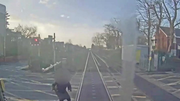 <p>Woman comes 'within half a second of being hit by train' at level crossing.</p>
