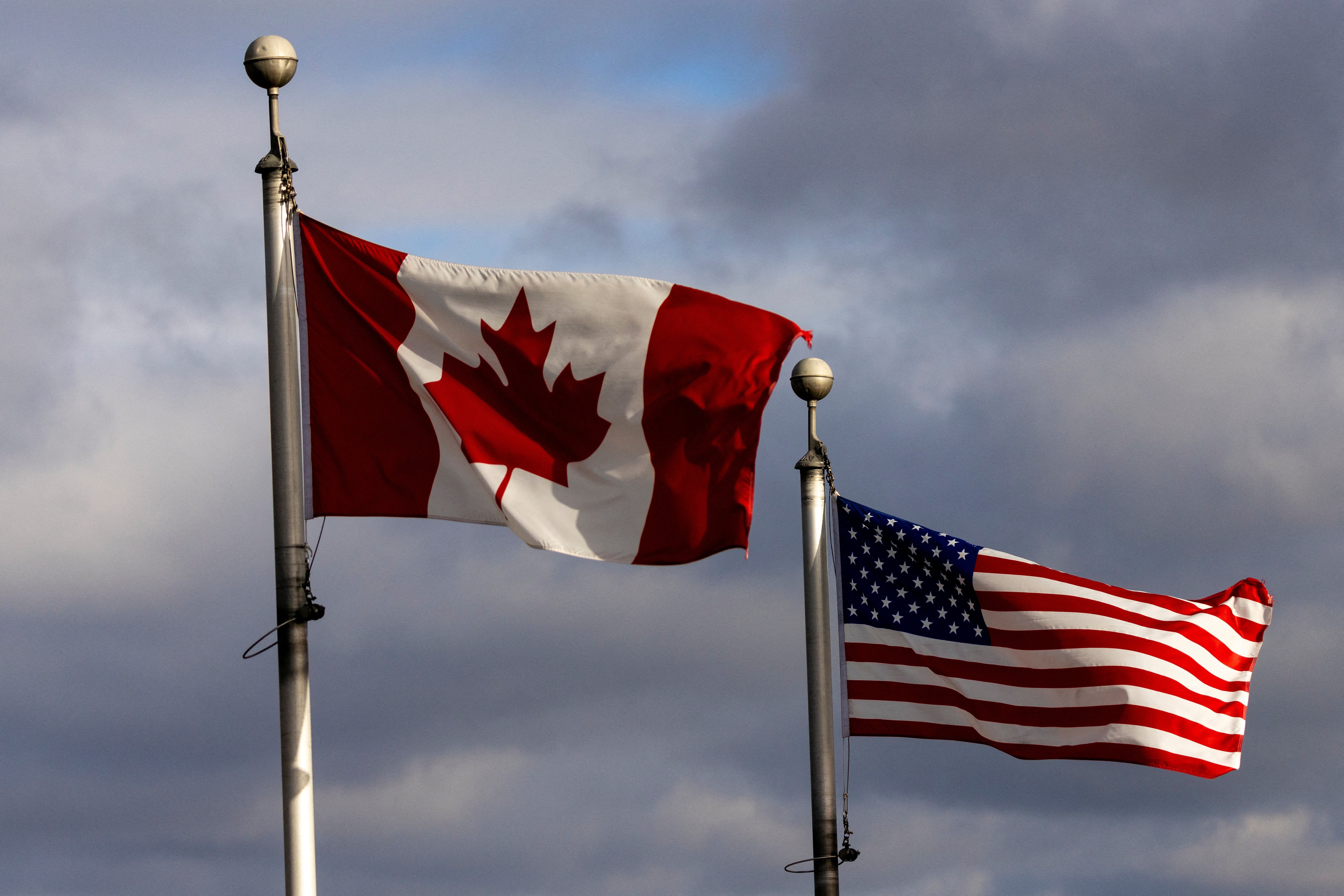 <p>The Canada and US flags wave near the Detroit River, which separates Windsor, Ontario, and Detroit, Michigan</p>