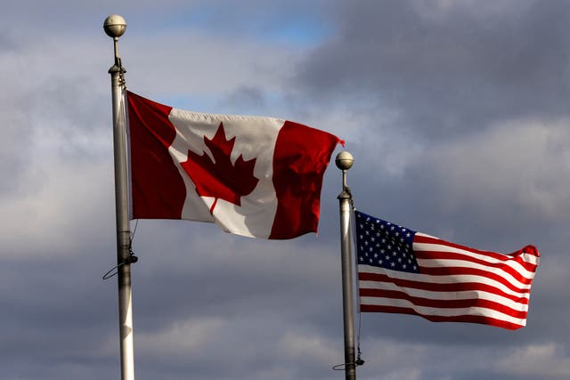 <p>The Canada and US flags wave near the Detroit River, which separates Windsor, Ontario, and Detroit, Michigan</p>