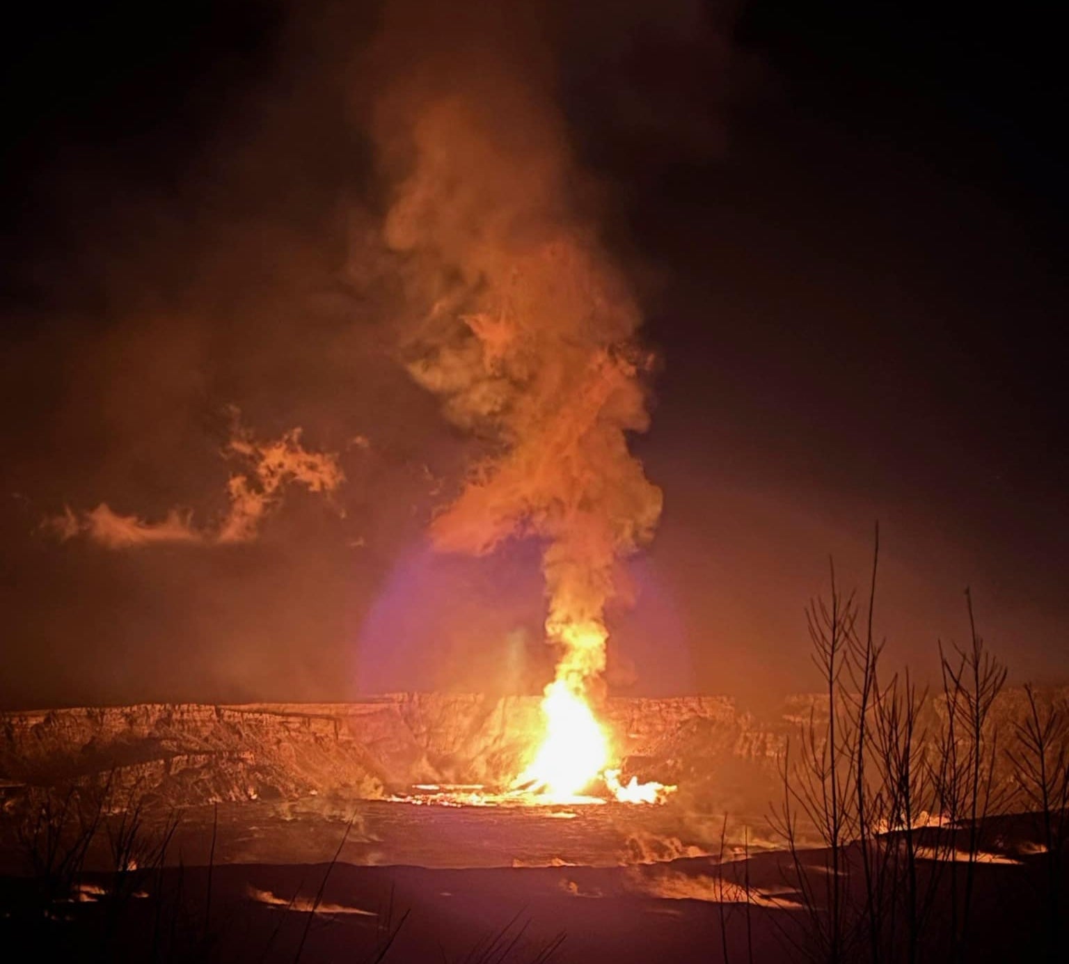 <p>A lava fountain erupting and gushing molten lava onto a crater floor taken from Kūpinaʻi Pali in Hawaii</p>