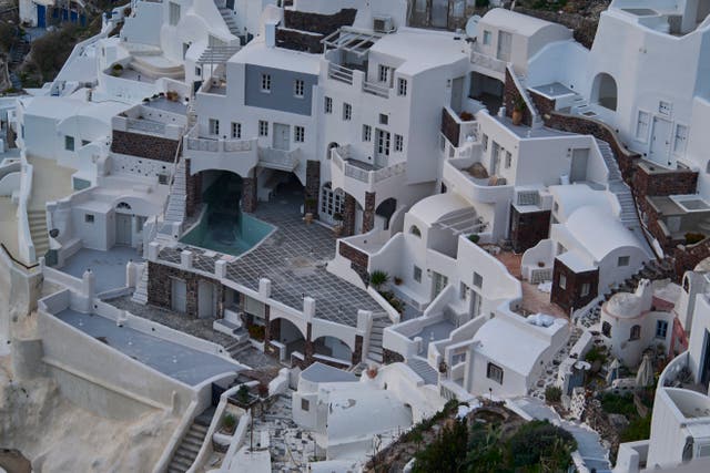 <p>An empty swimming pool is seen in a group of clifftop buildings in the town of Oia on the earthquake-struck island of Santorini</p>