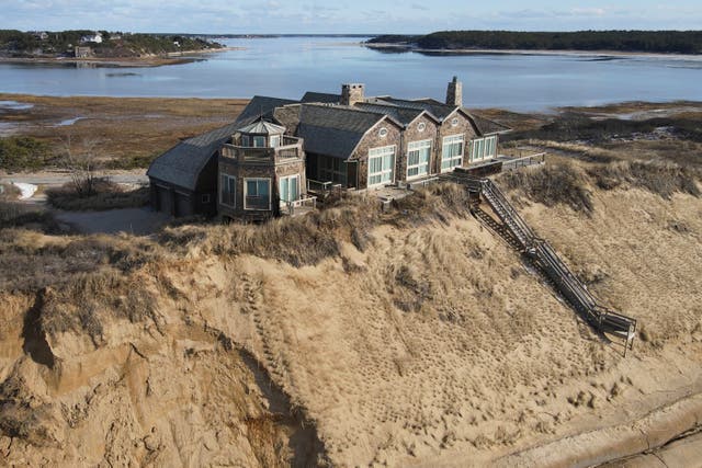 <p>A home sits atop of a sandy bluff overlooking a beach in Wellfleet, Mass, Wednesday, Feb. 2, 2022</p>