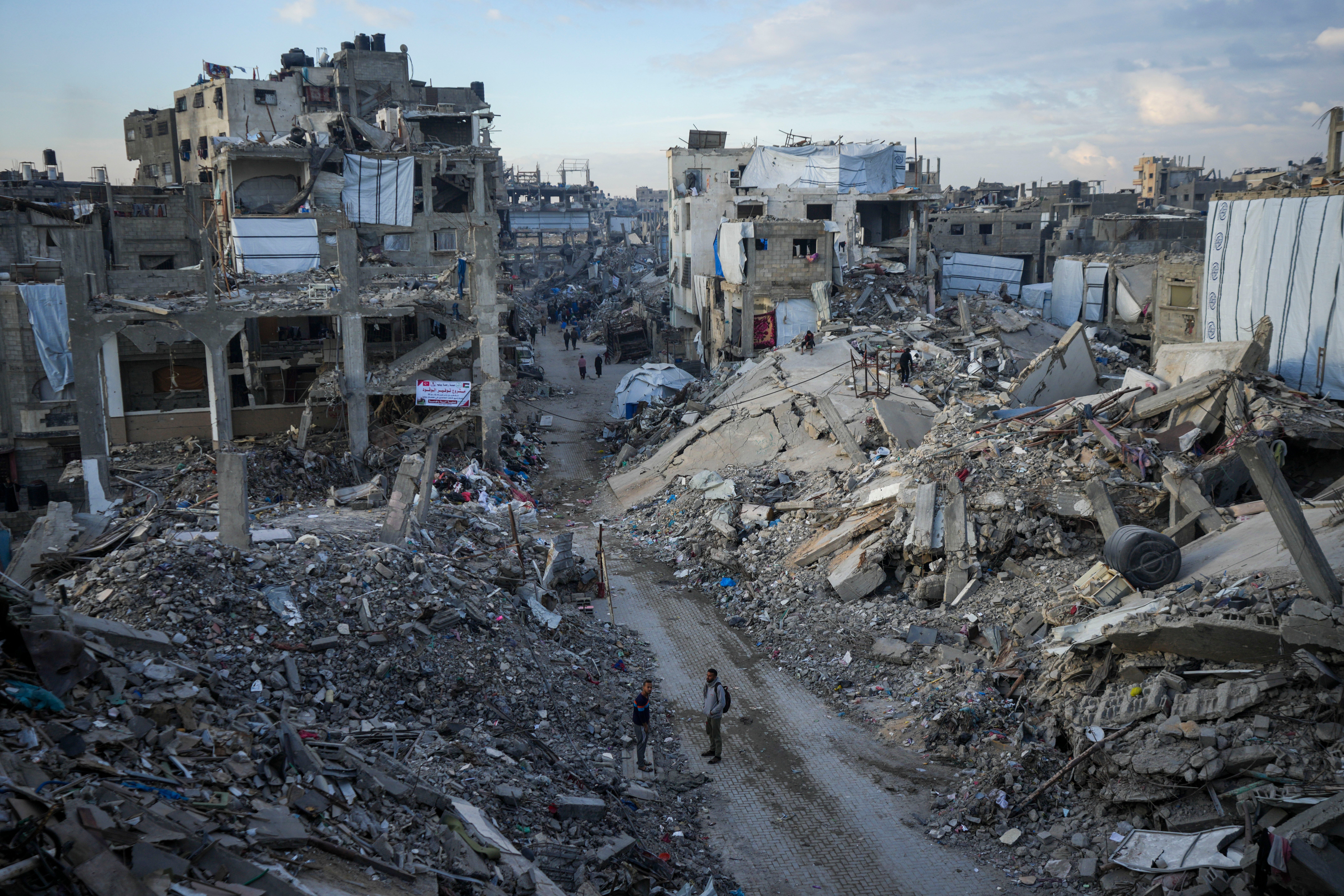 Palestinians walk in the destruction caused by the Israeli air and ground offensive in Jabaliya, Gaza Strip, Wednesday, Feb. 5, 2025.