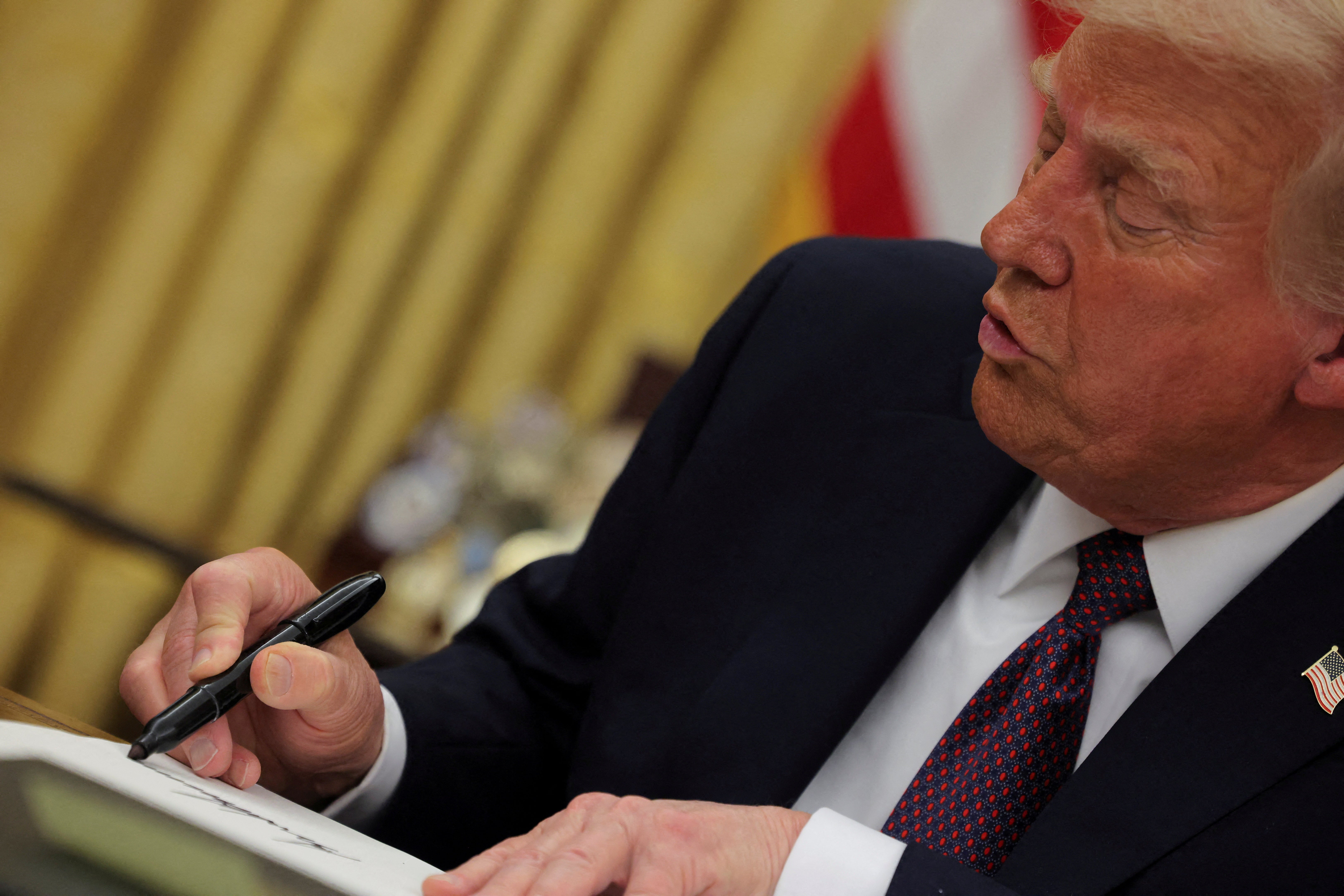 President Donald Trump signs an executive order. There are several parallels between Project 2025 and the many orders he has signed since taking office