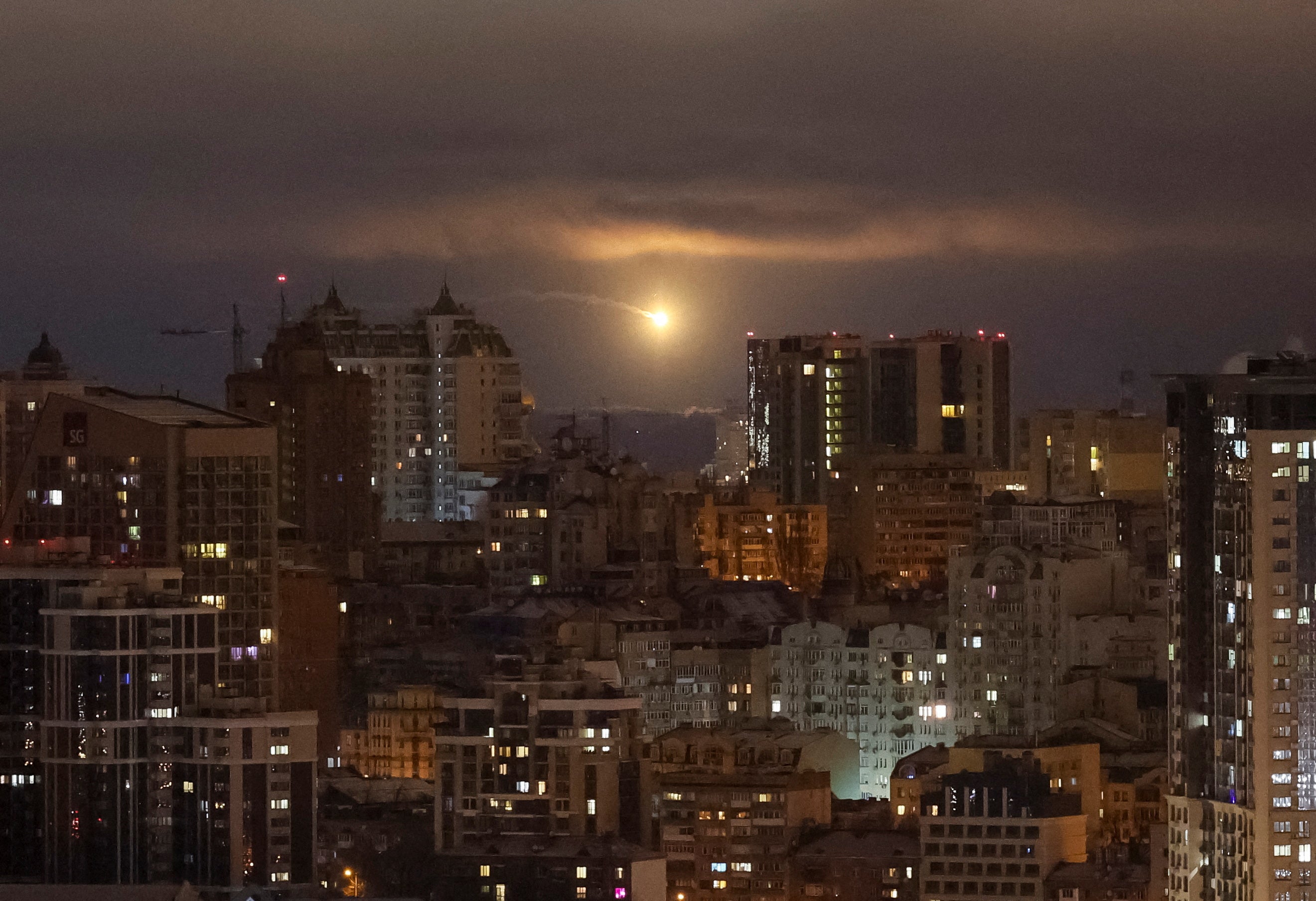 An explosion of a drone is seen in the sky over the city during a Russian drone strike amid Russia's attack on Kyiv