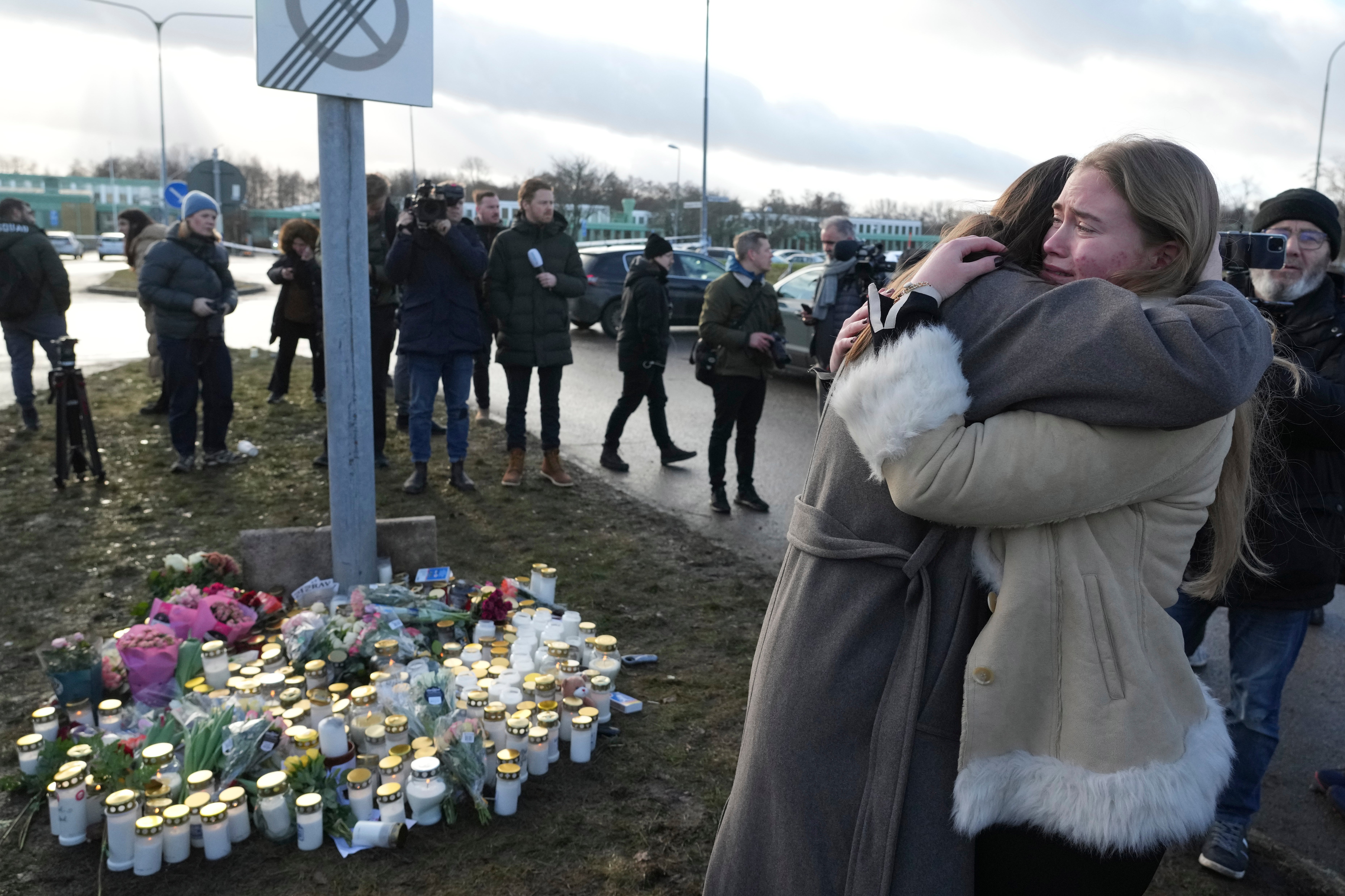 People gather at a memorial near the scene of a shooting in the outskirts of Orebro, Sweden