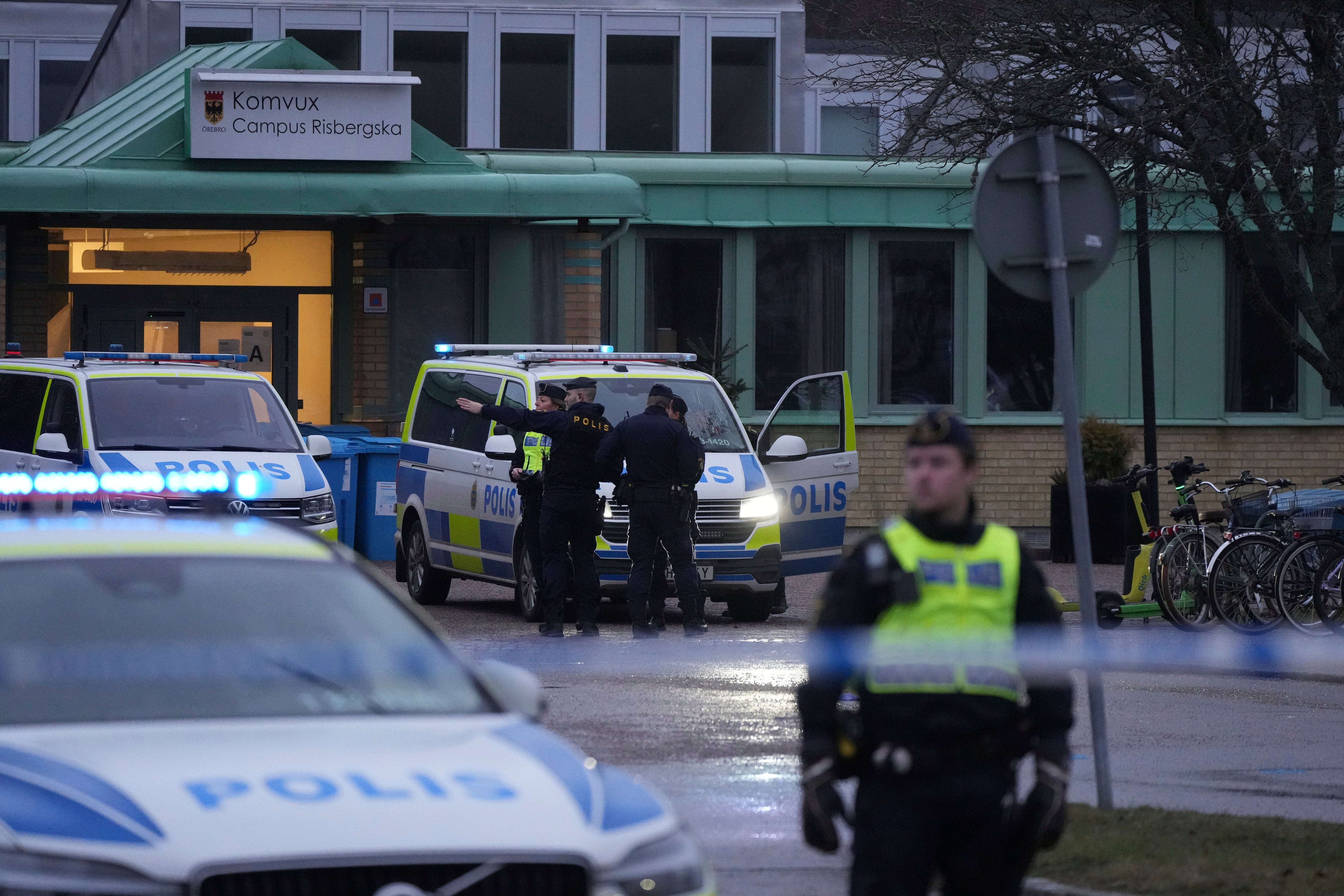 Police officers stand guard near the scene of the shooting at an adult education centre on the outskirts of Orebro in Sweden