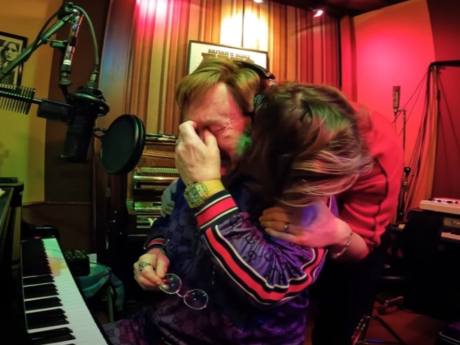 Elton John is hugged by Brandi Carlile as he sobs during an emotional moment