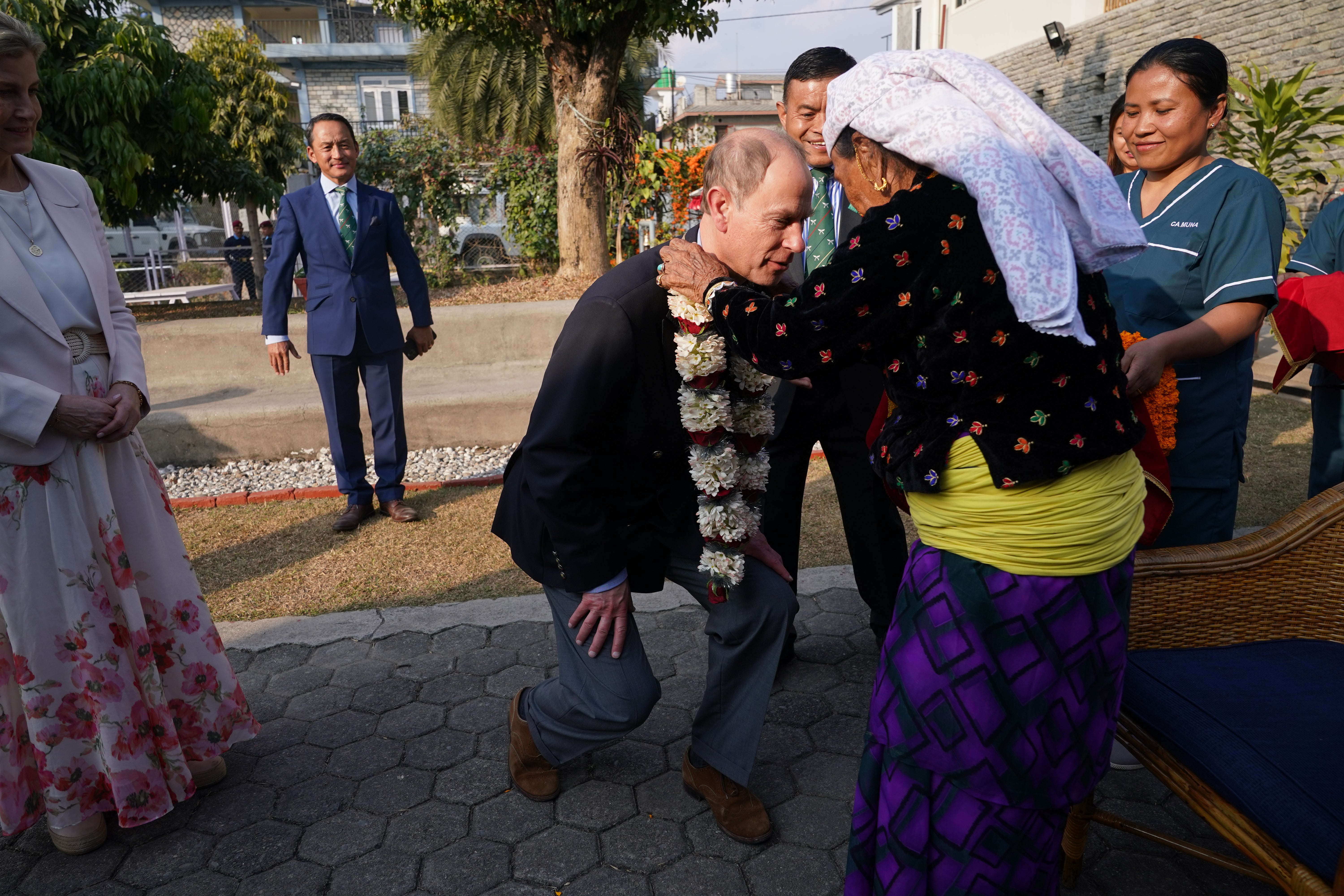 The Duke of Edinburgh is presented with a garland by Ash Kumari Tamang, a 104-year-old Gurkhan widow.