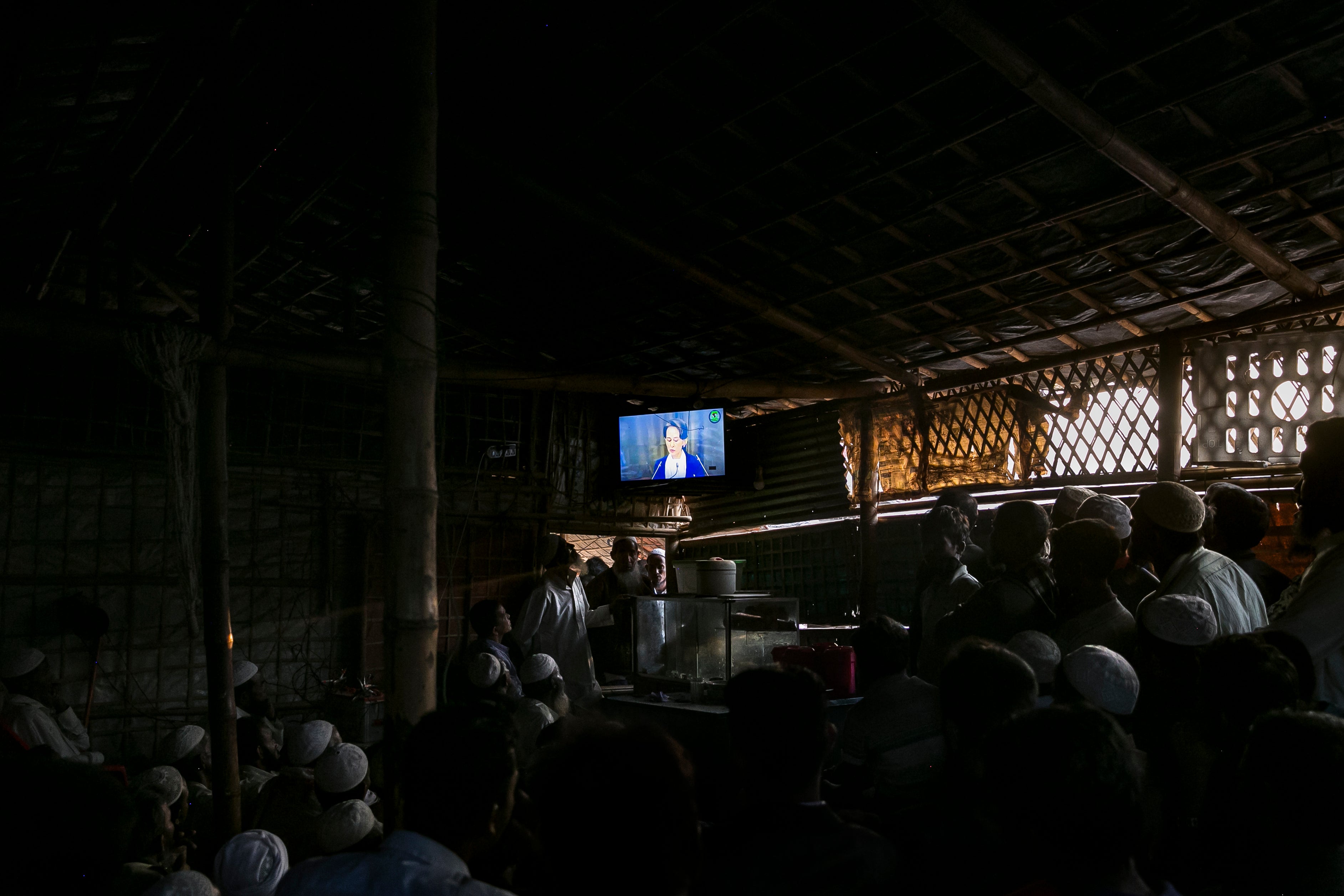 Rohingya refugees watching news in a Cox Bazar camp