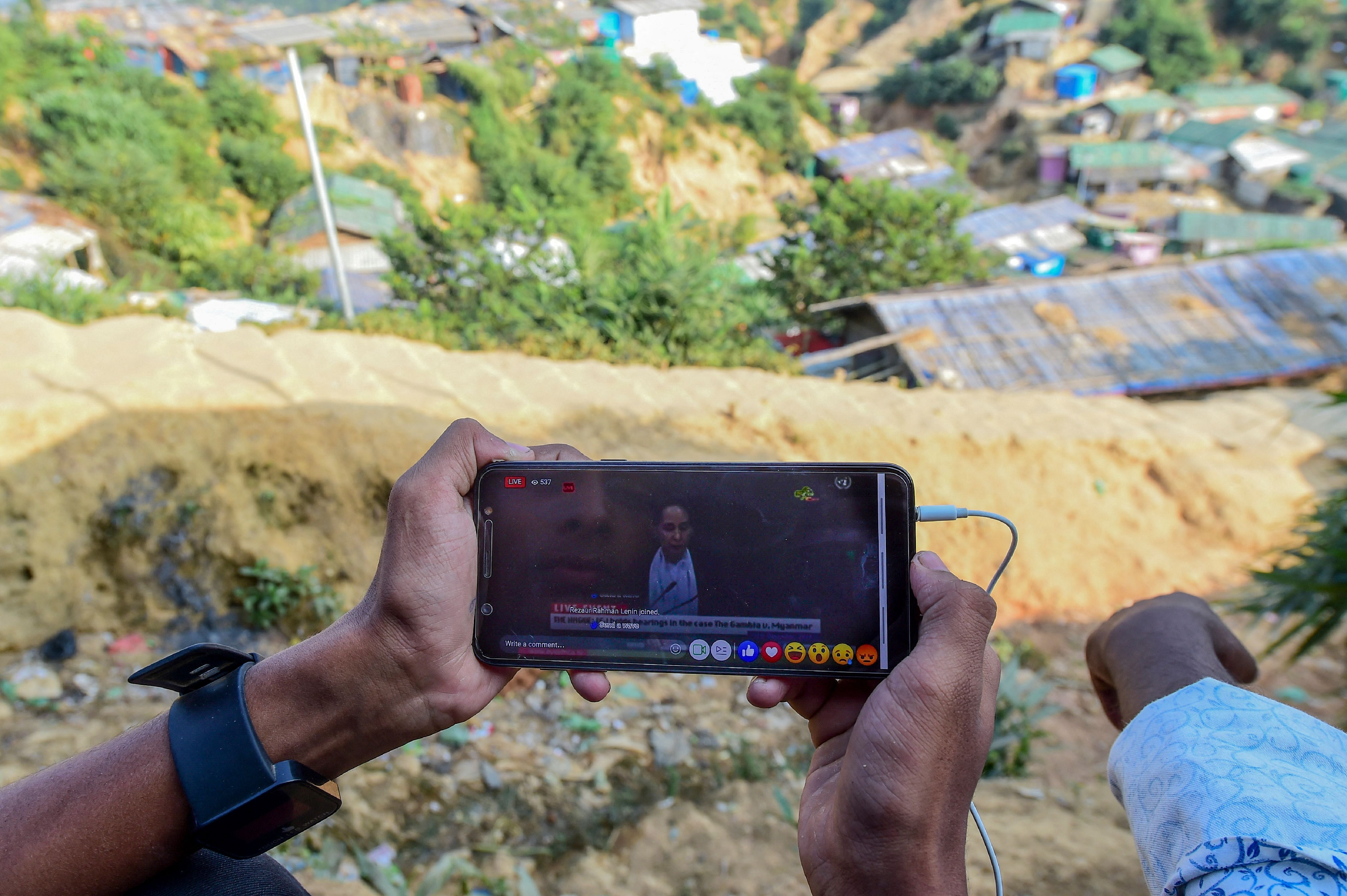 A Rohingya refugee watches a live feed of Aung San Suu Kyi's appearance at the UN's International Court of Justice in the Hague from a refugee camp in Cox's Bazar in December 2019