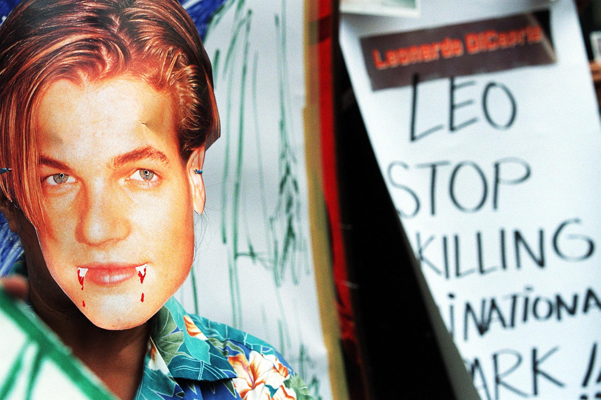 The ecological activist wears DiCaprio's mask (complete with vampire teeth) during a protest in 1999 in Bangkok