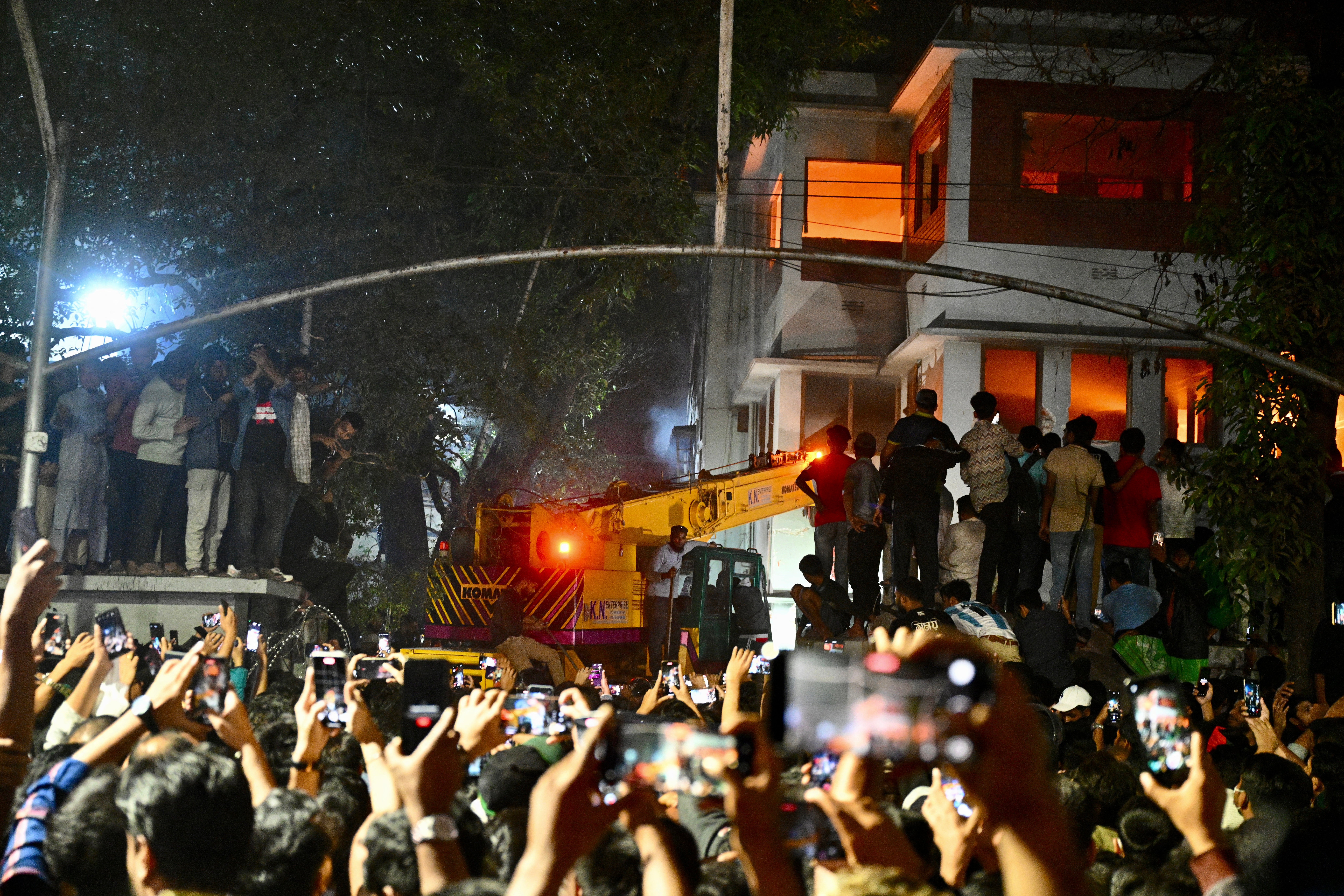 Protesters use a crane truck to demolish the Bangabandhu Memorial Museum, the former residence of Sheikh Mujibur Rahman father of the former Prime Minister Sheikh Hasina, as they storm the Museum