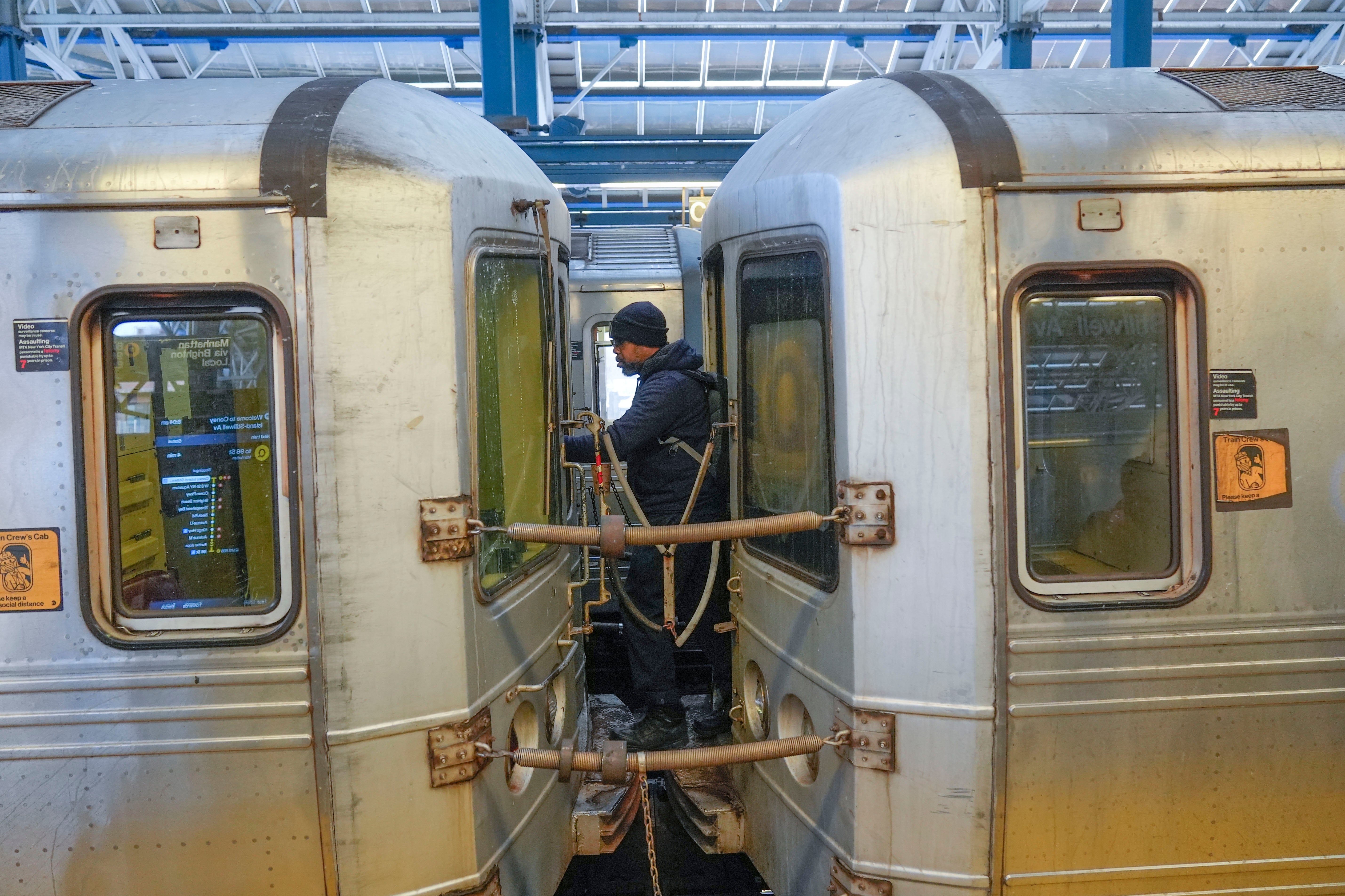 Seorang konduktor kereta berjalan di antara mobil Subway di sebuah stasiun